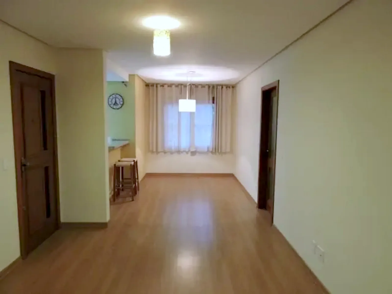 Sala ampla com piso laminado e janela