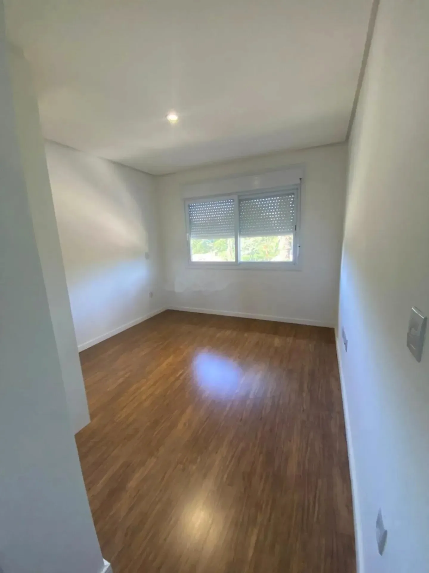 Suíte com janela e piso laminado