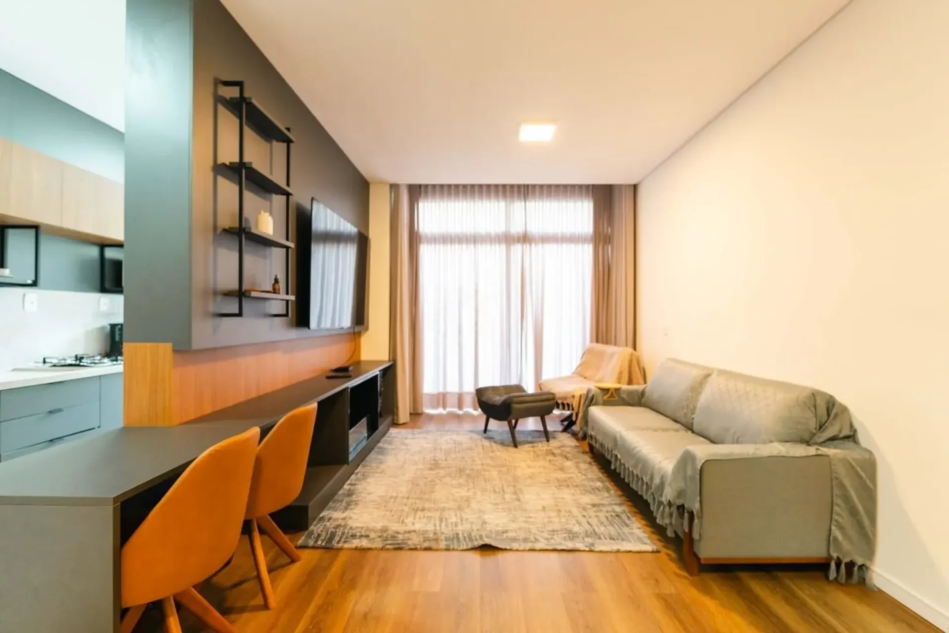 Living mobiliado com painel em madeira, no Centro de Canela