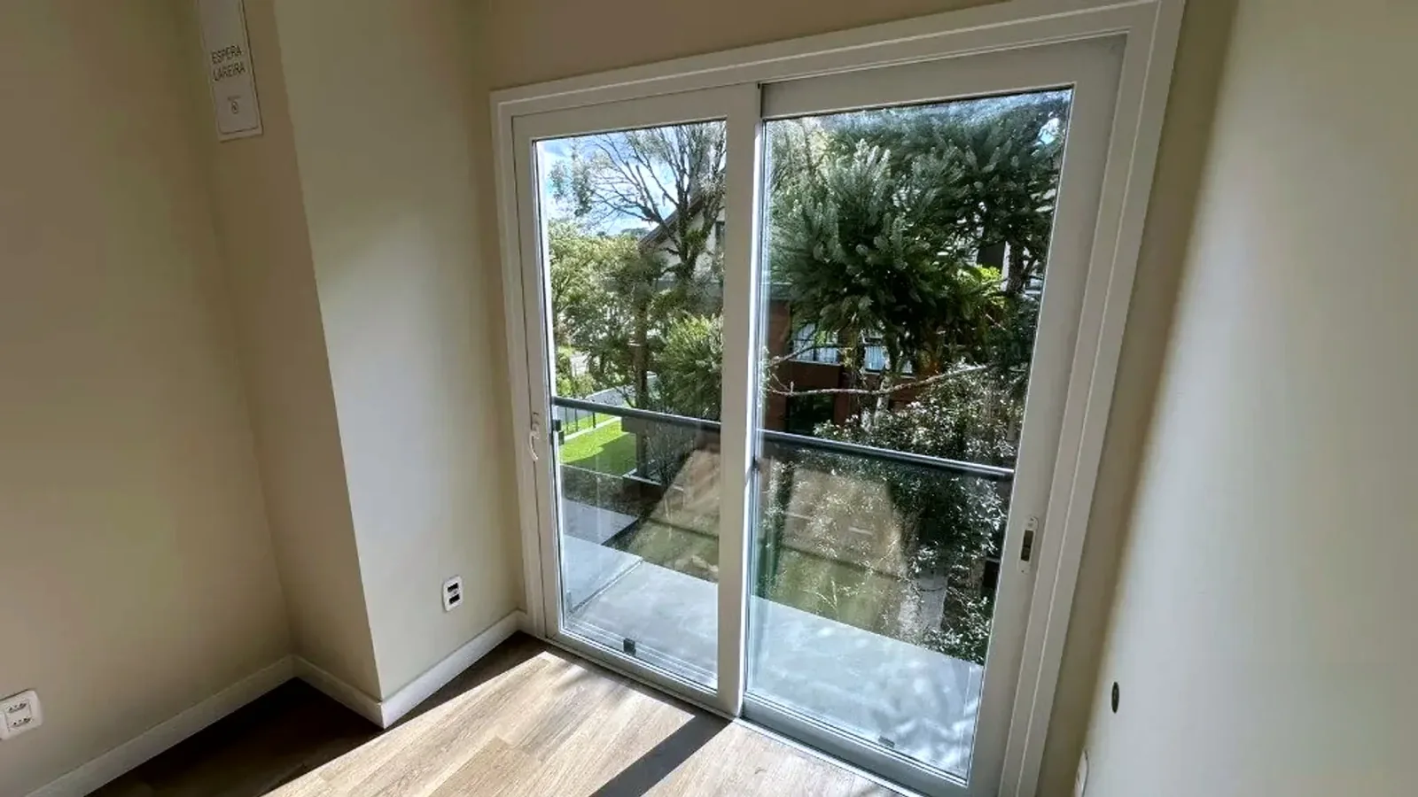 Living com porta de vidro para a sacada