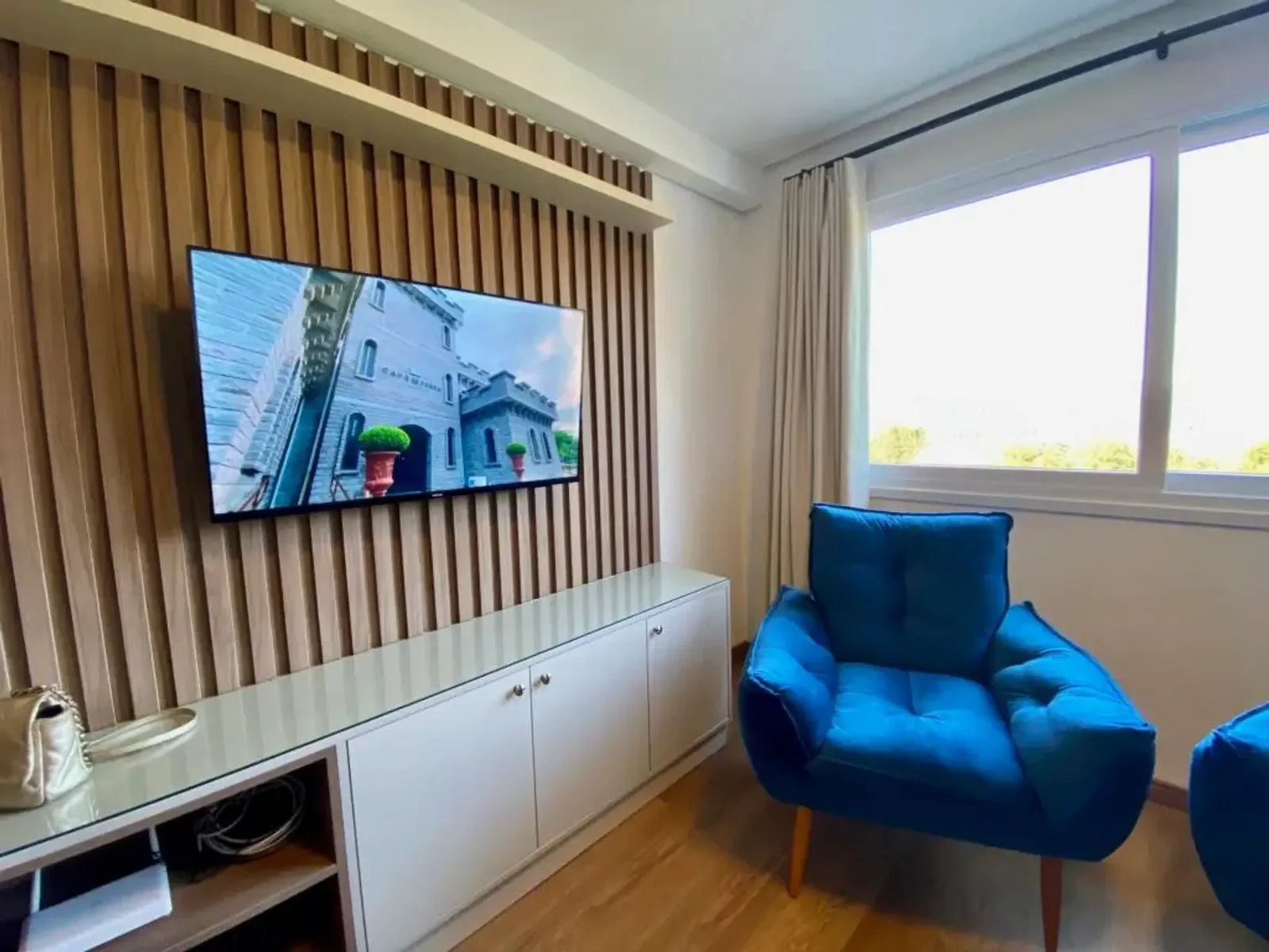 Sala com painel de TV e poltronas