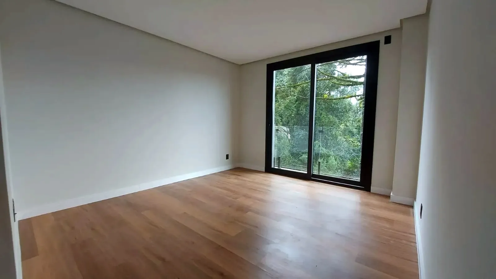 Living com janela do piso ao teto para o verde