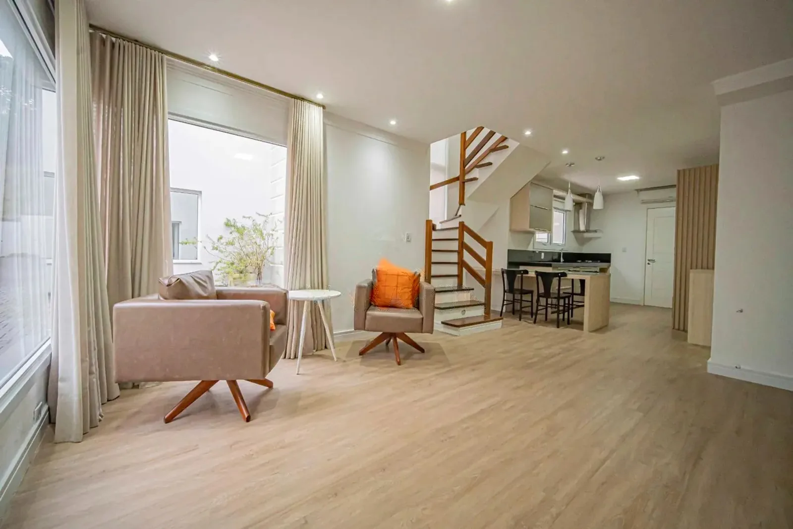 Living mobiliado com escada para o andar de cima