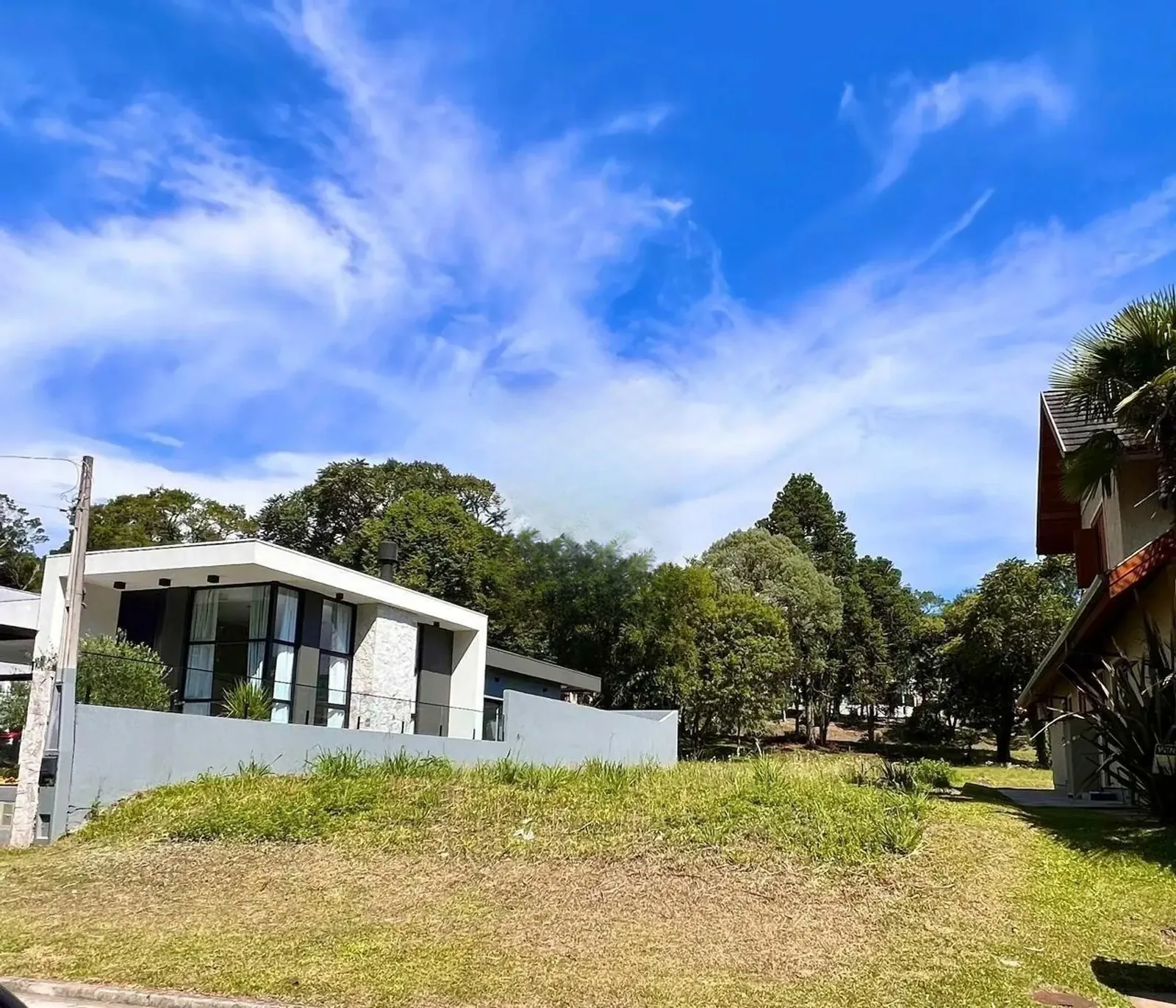 Terreno plano e gramado com casas vizinhas