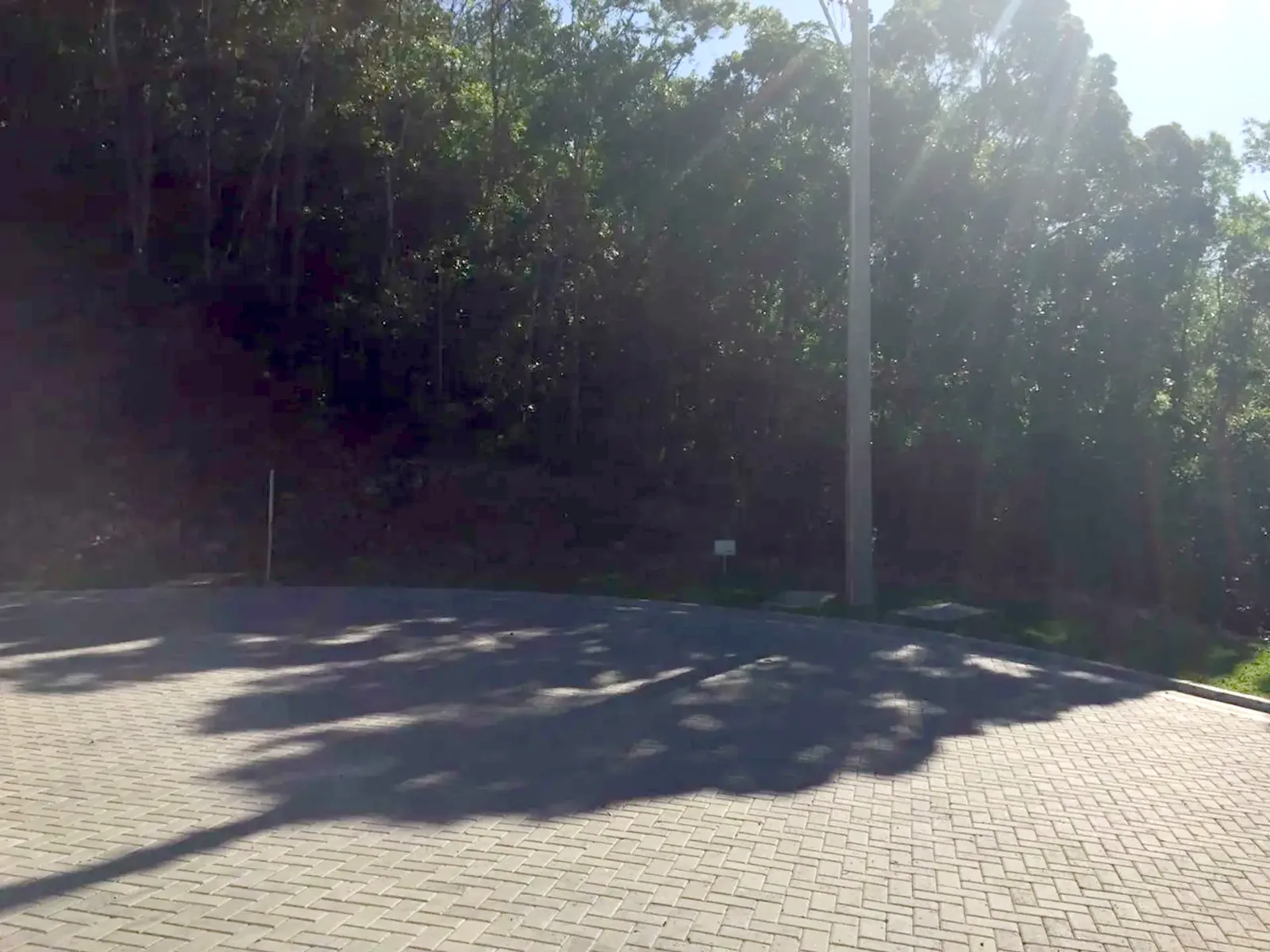Trecho sombreado da rua em frente ao lote