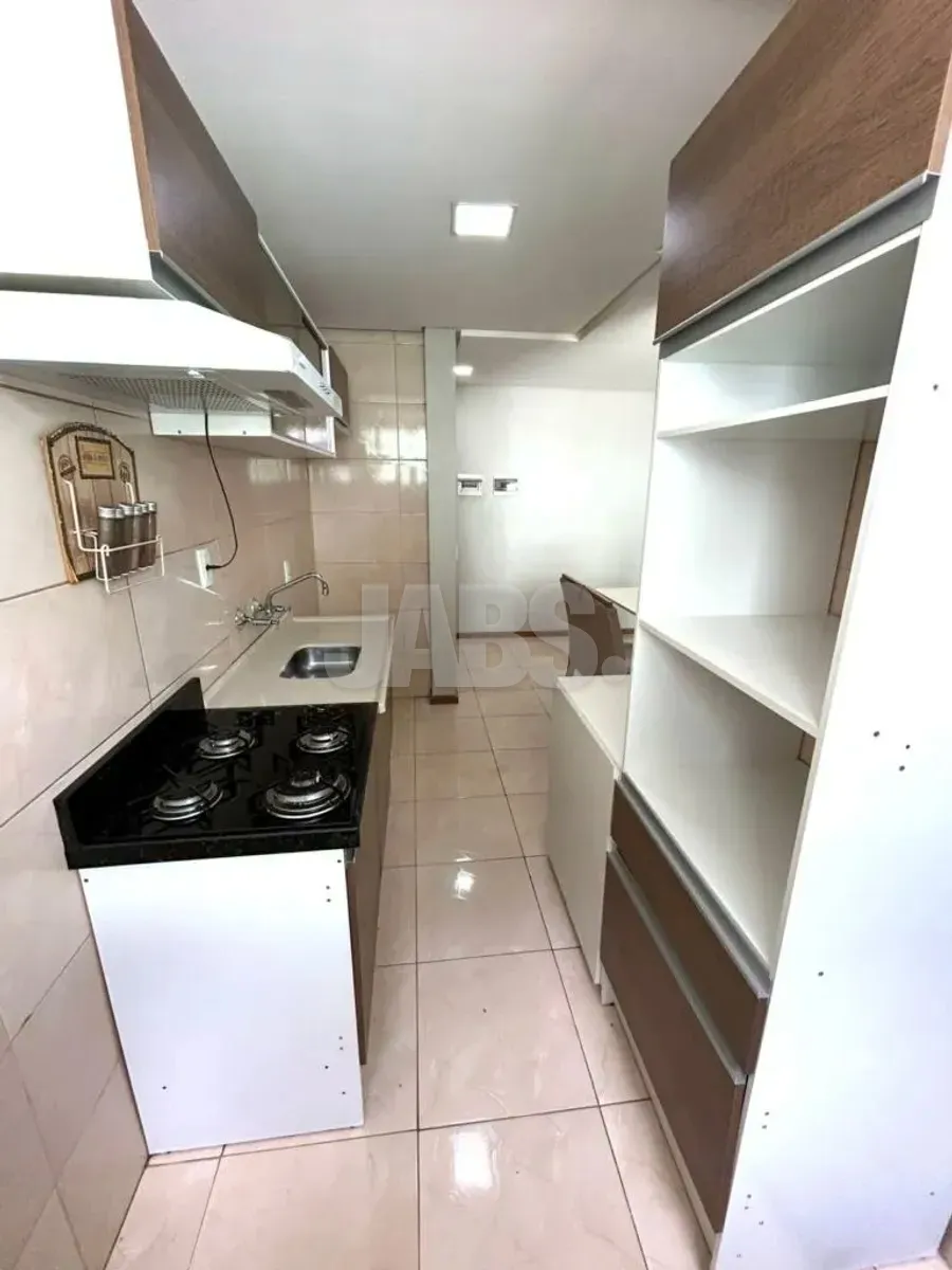 Cozinha com armários planejados, cooktop e prateleiras