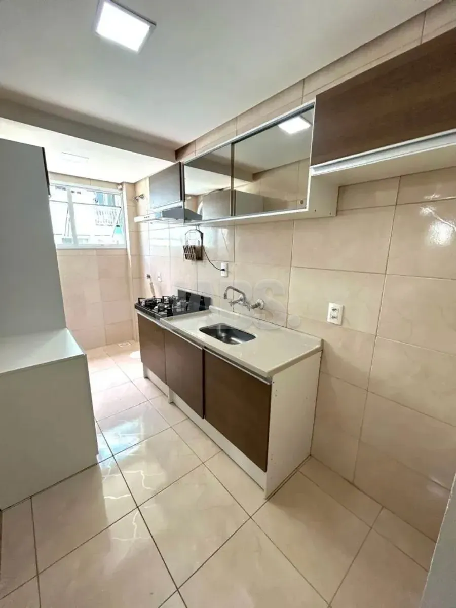 Cozinha com bancada, pia e armários aéreos