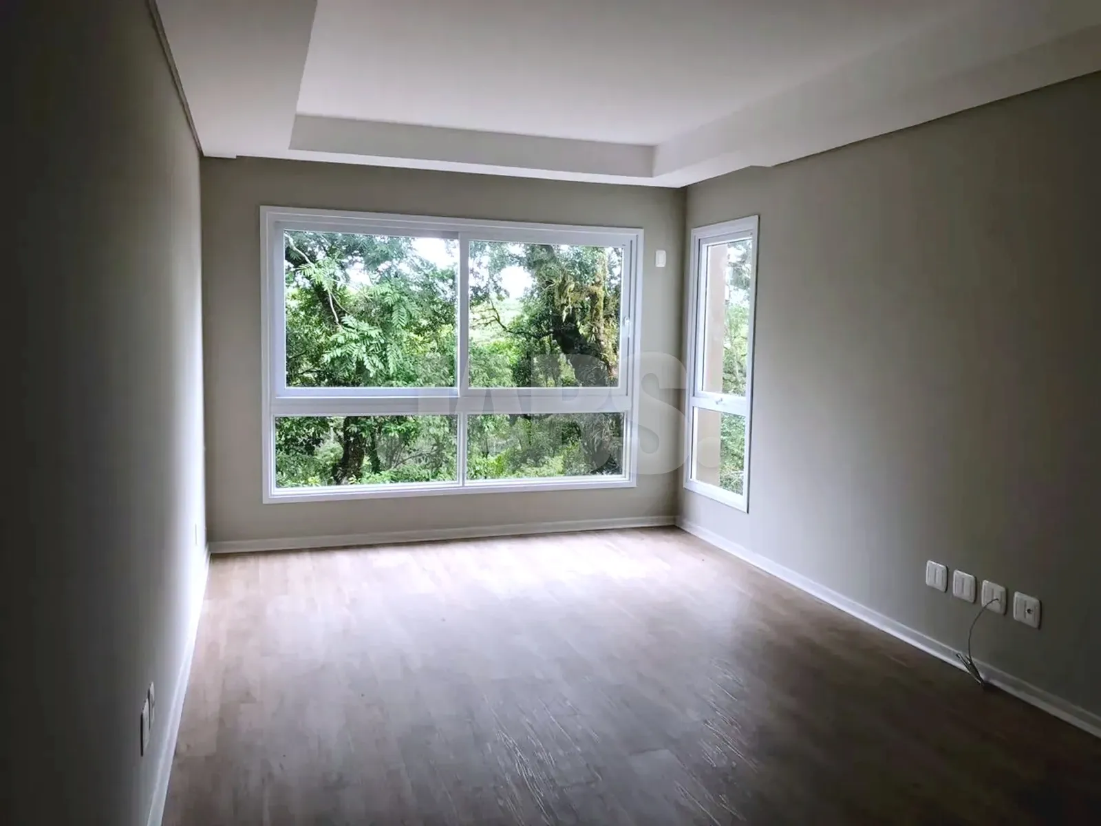 Living com duas janelas e piso laminado