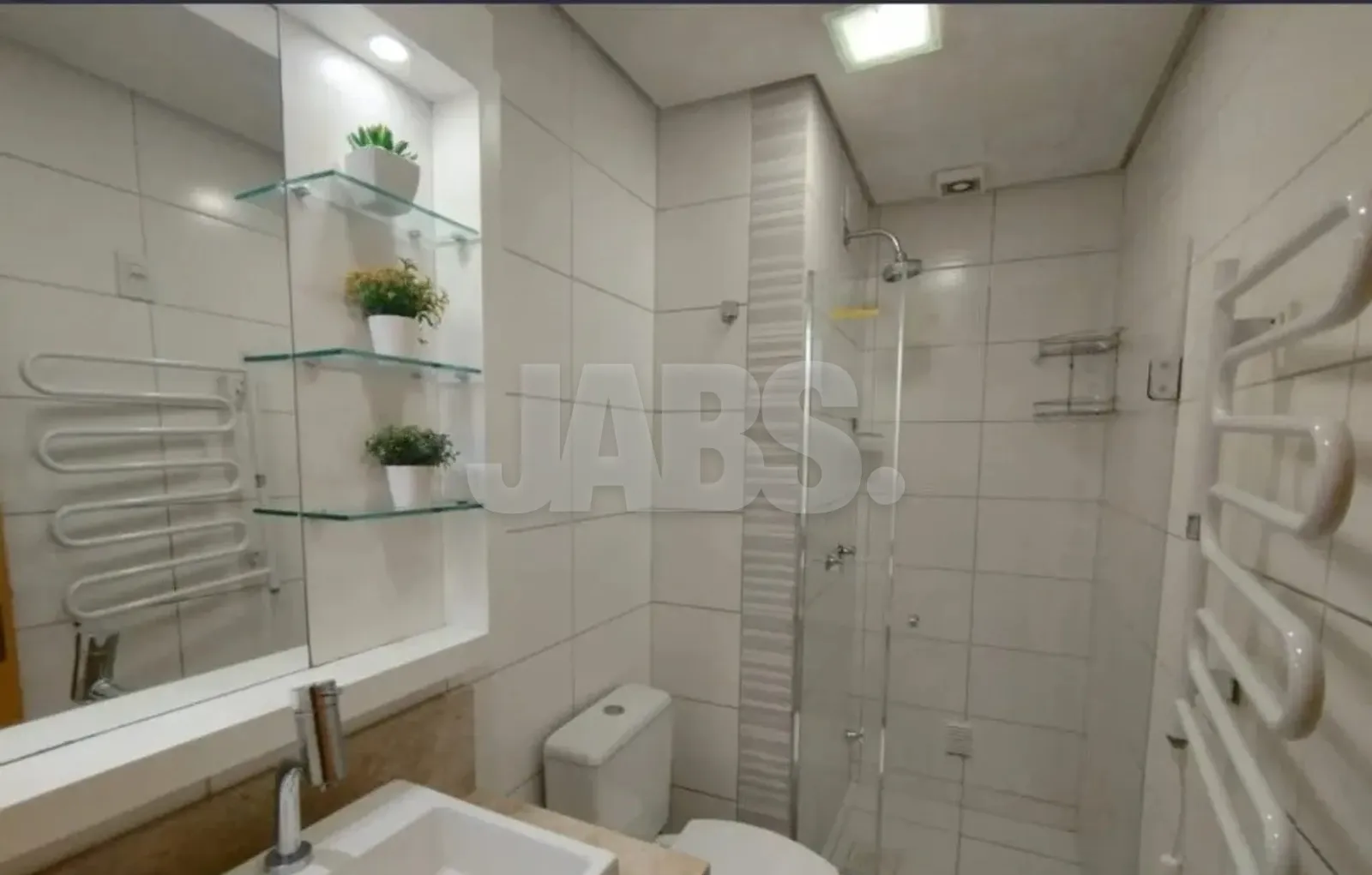 Banheiro com box de vidro e toalheiro aquecido
