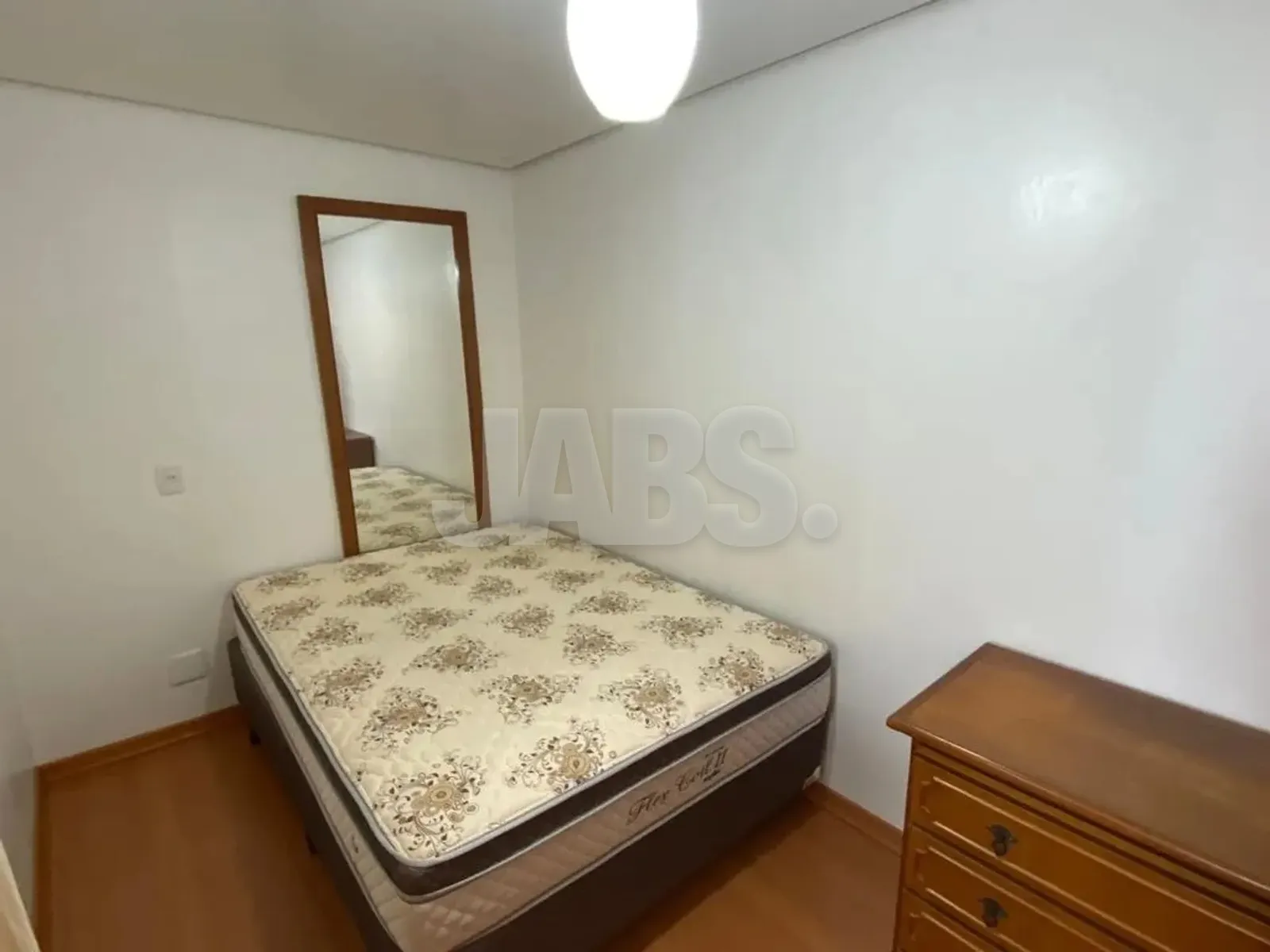 Dormitório com cama de casal e espelho