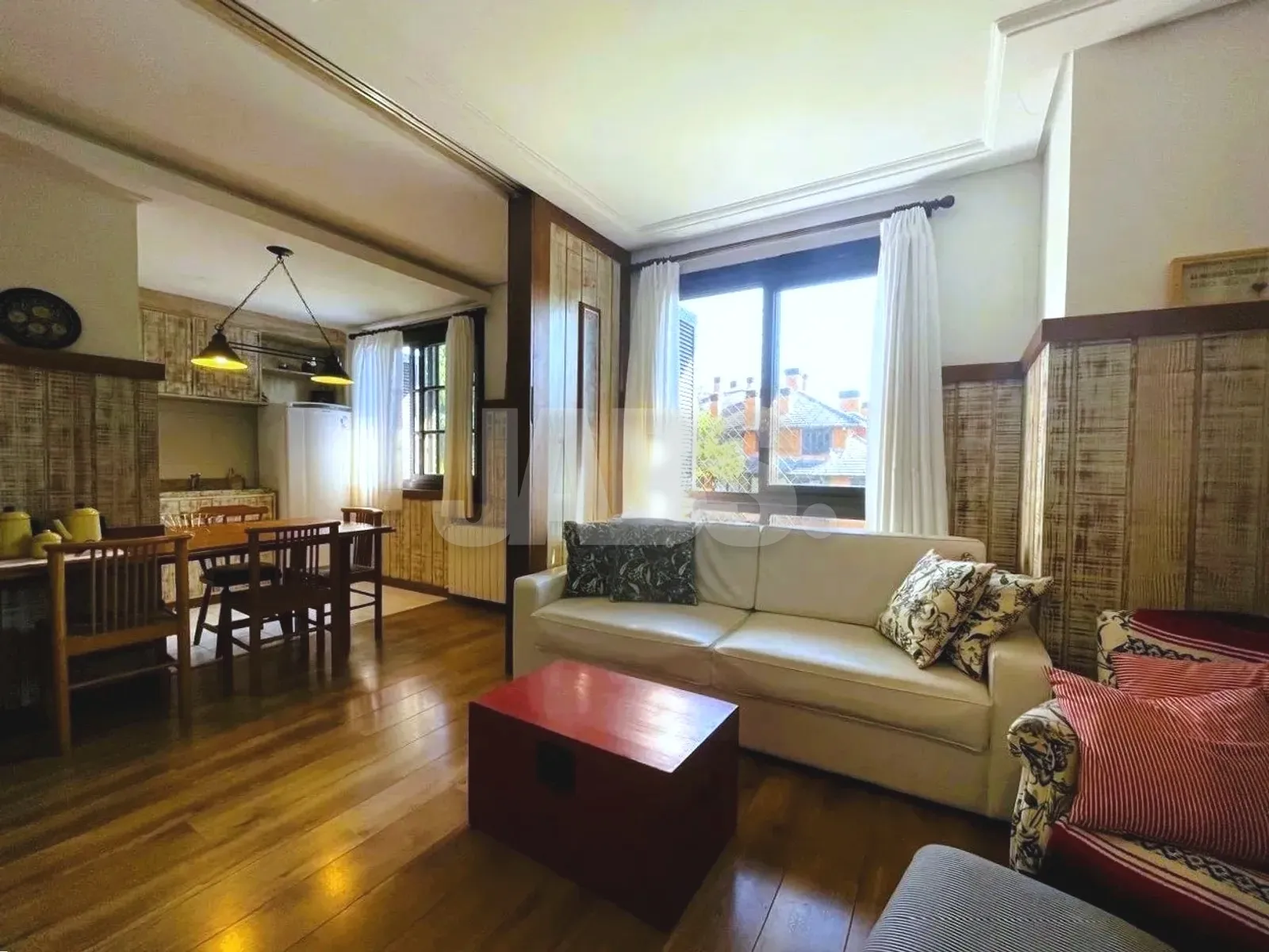 Sala de estar com sofá e janela para o verde