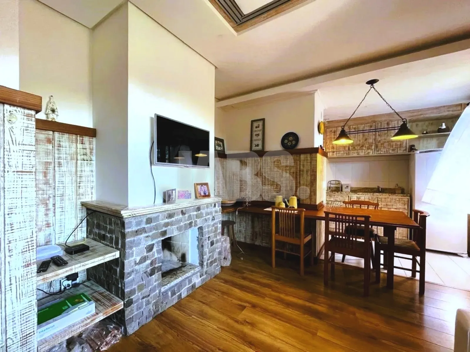 Sala com lareira de pedra e mesa de jantar