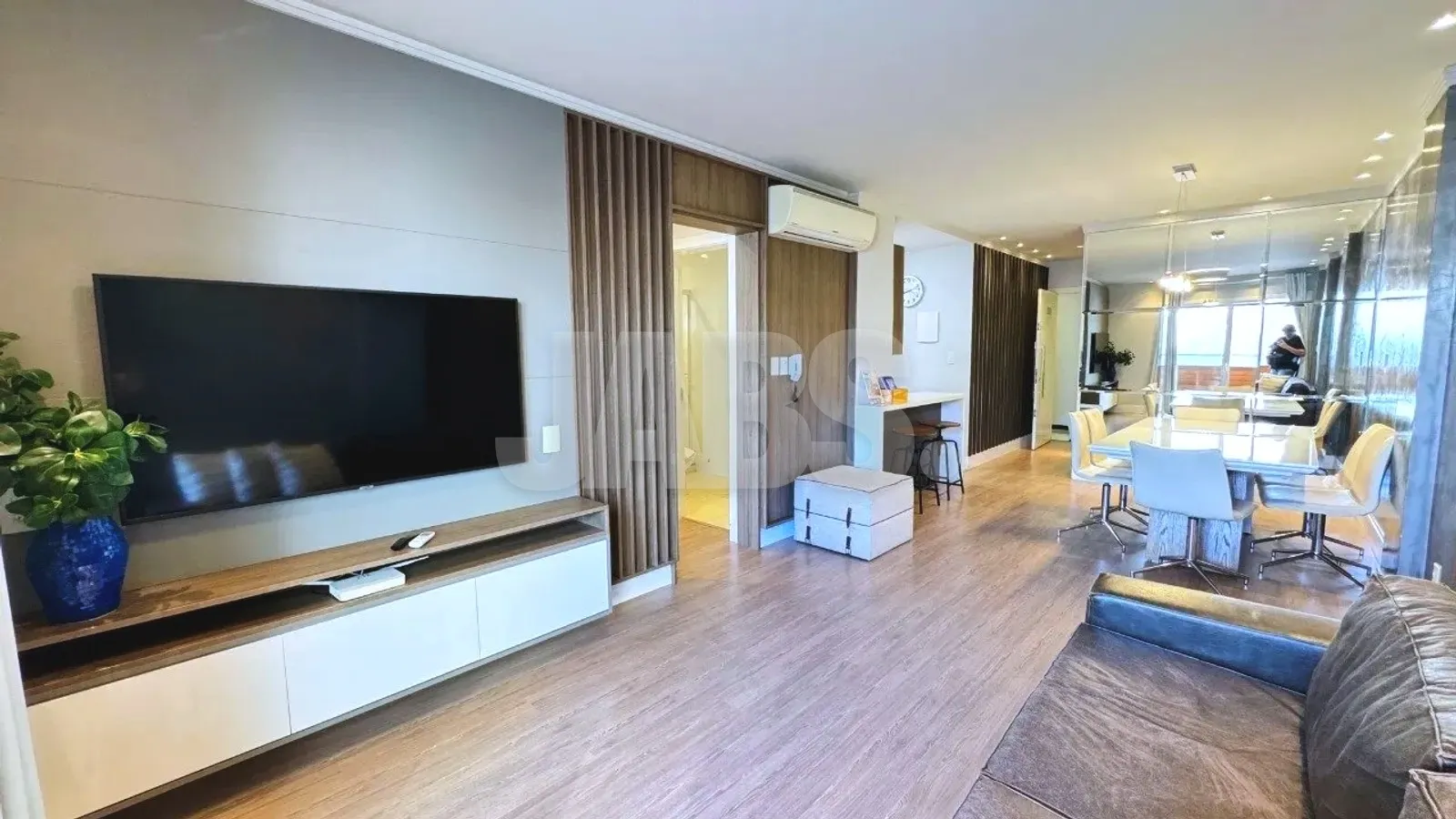 Living integrado com TV e mesa de jantar ao fundo