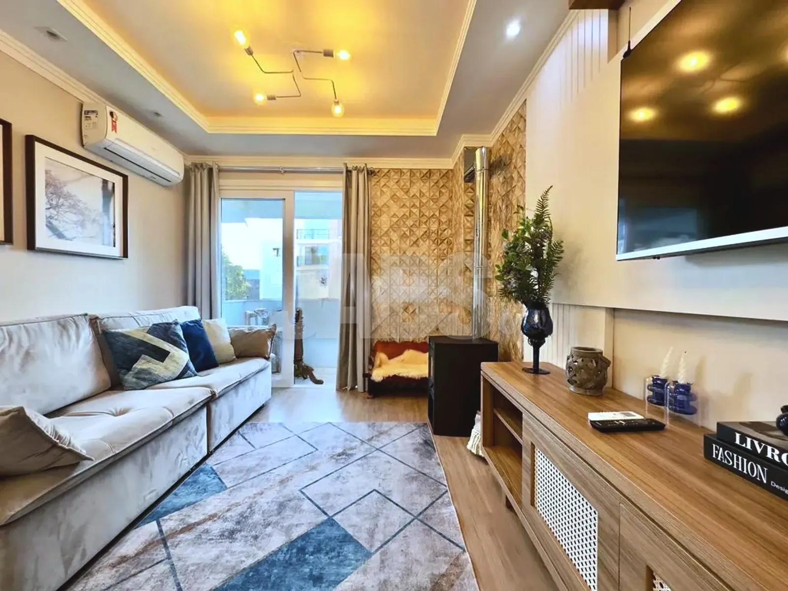 Sala com sofá, televisão e iluminação embutida