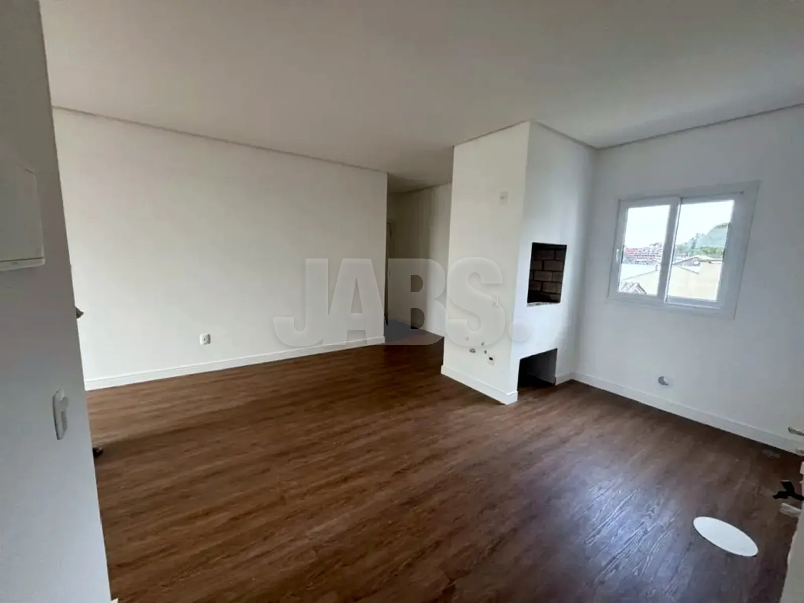 Living com coluna da churrasqueira e piso em tom de madeira