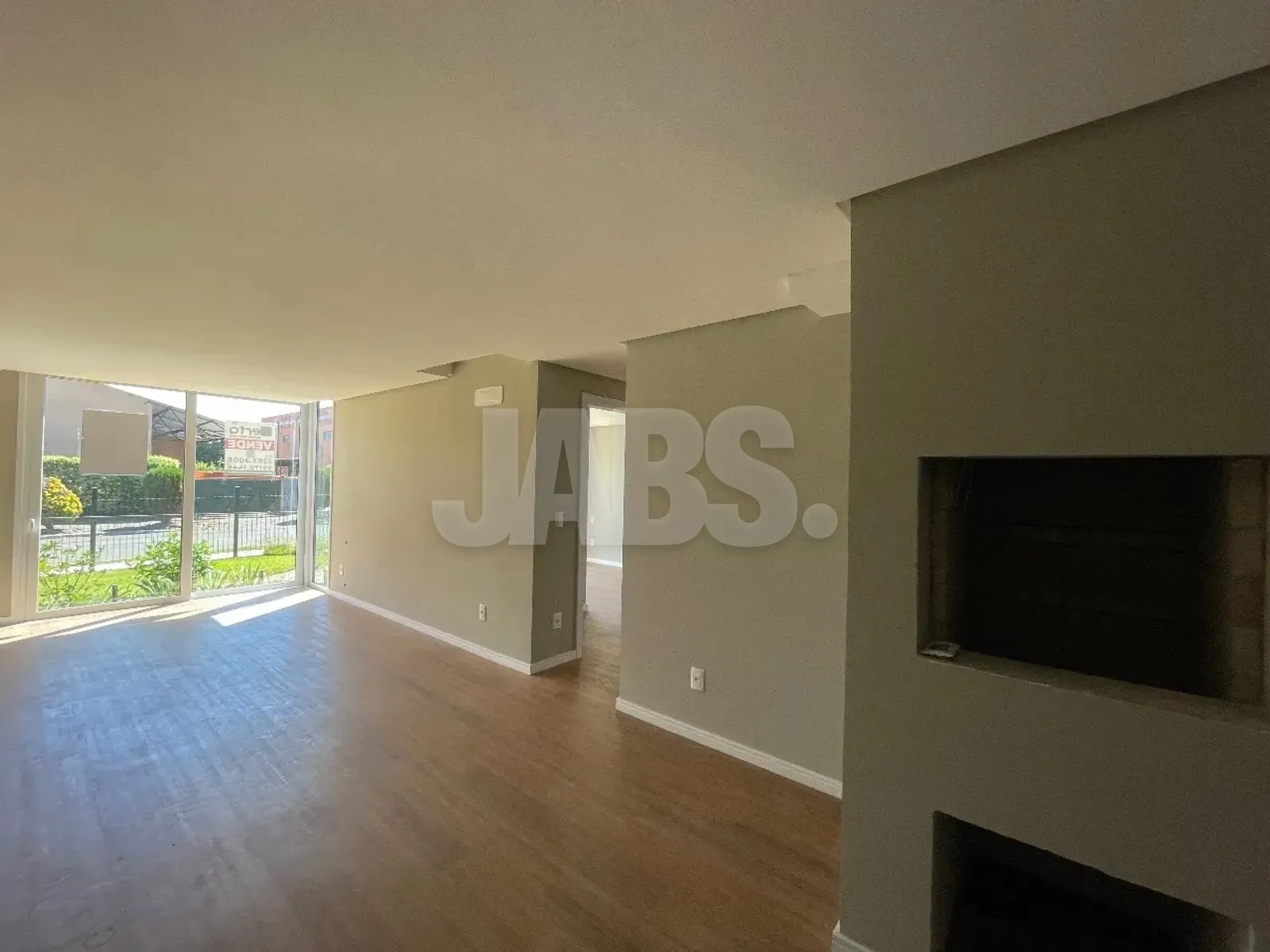 Living com churrasqueira e porta de vidro para fora