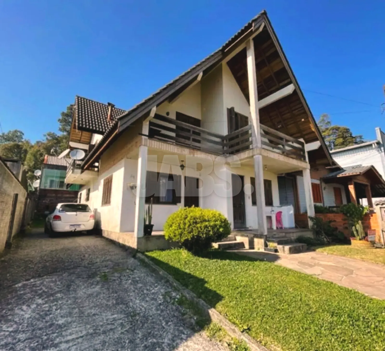 Fachada da casa em estilo alpino com jardim na frente