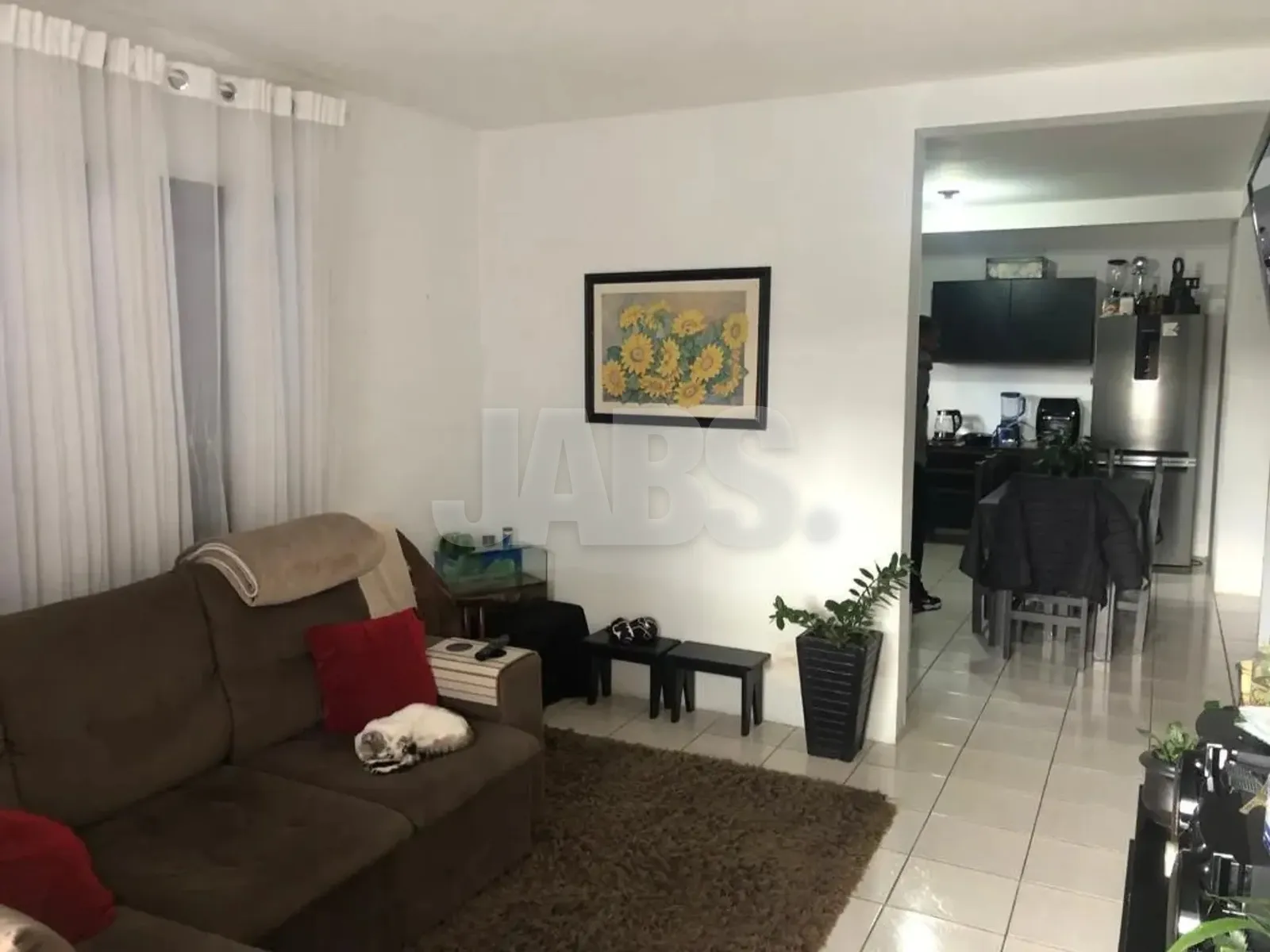Sala de estar com sofá e acesso à cozinha