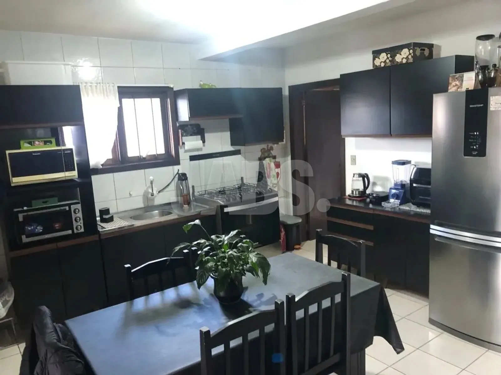 Cozinha com armários pretos e mesa de jantar