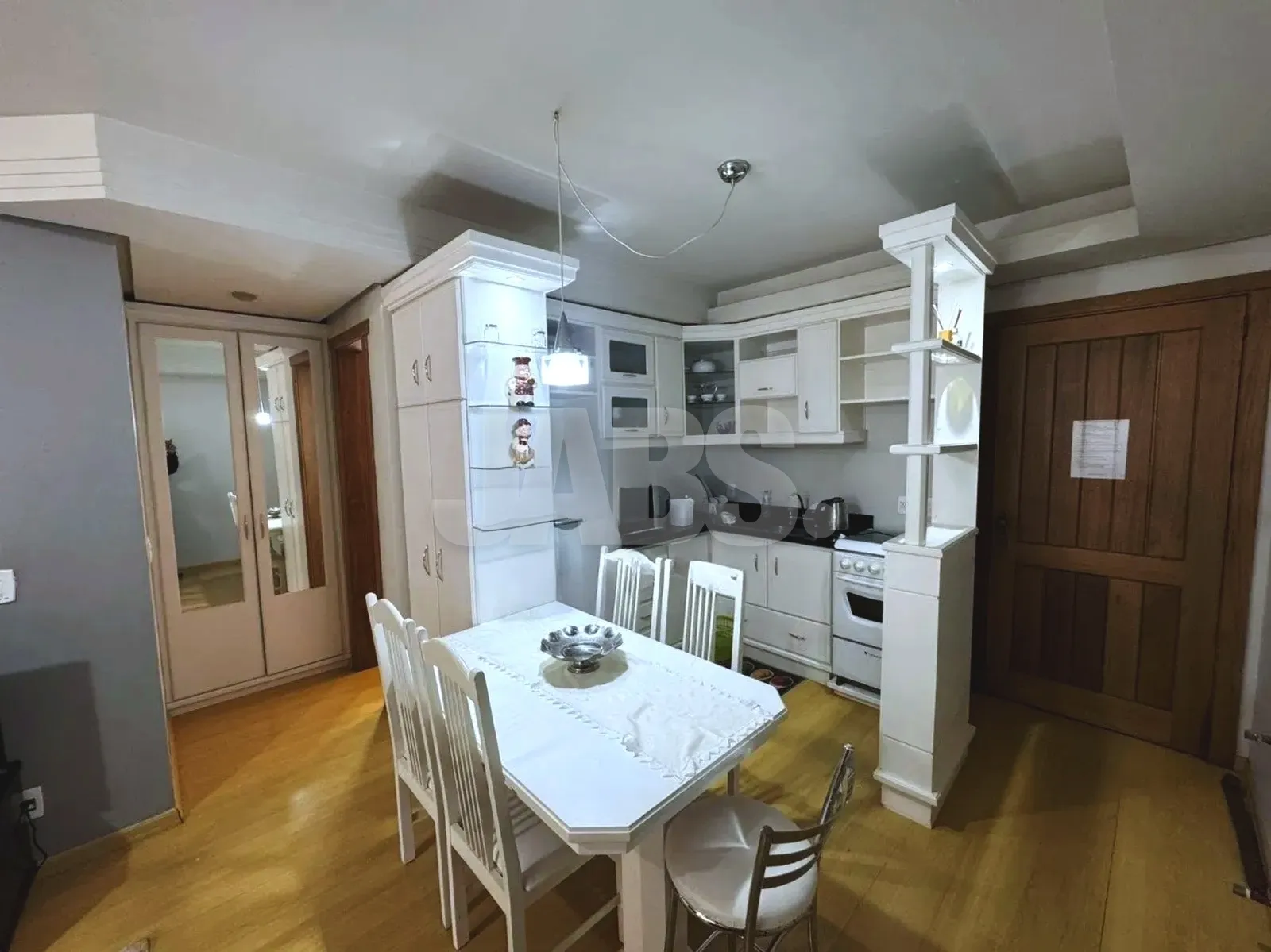 Cozinha americana com móveis planejados e mesa de jantar