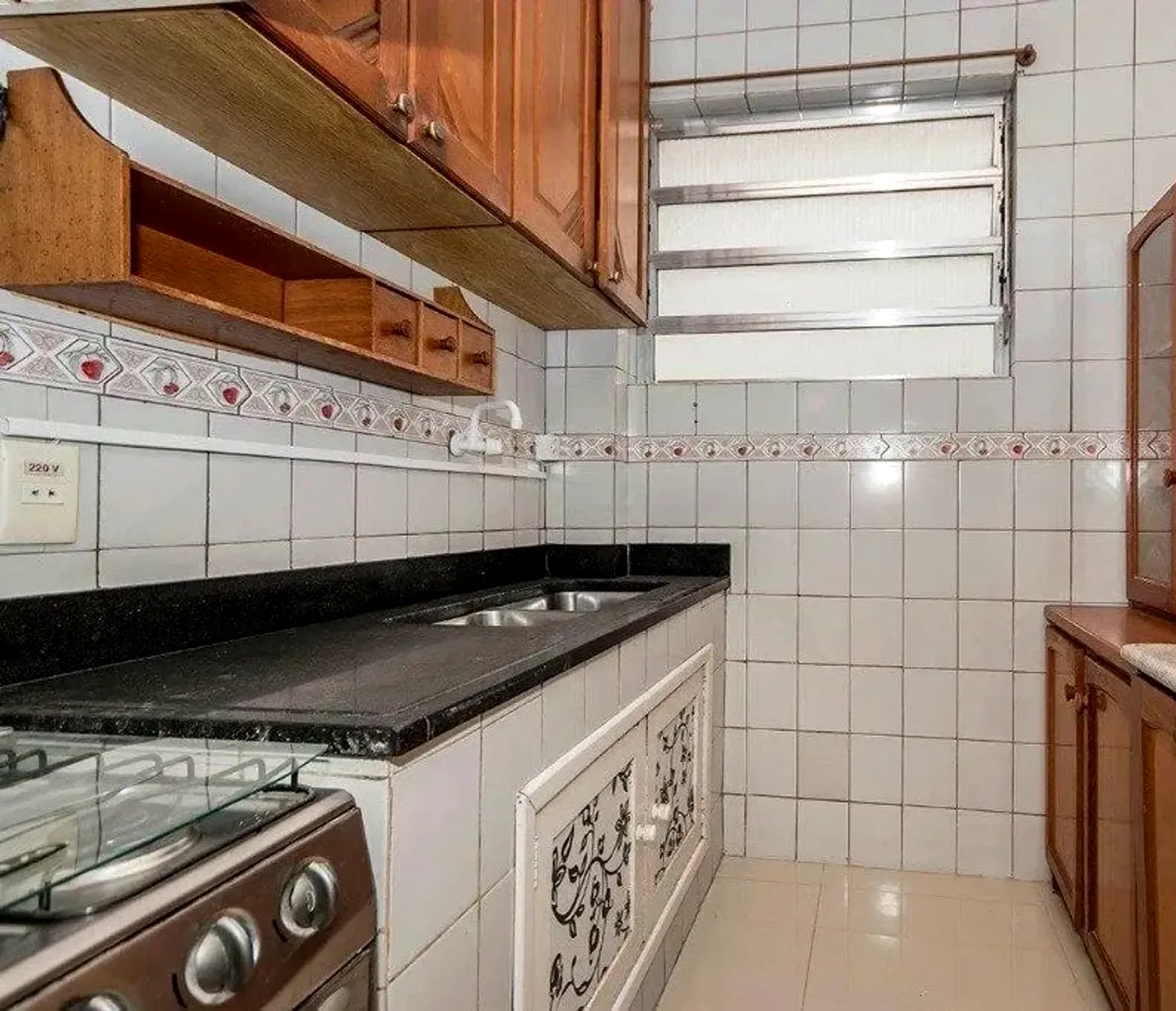 Cozinha com bancada de granito e armários de madeira