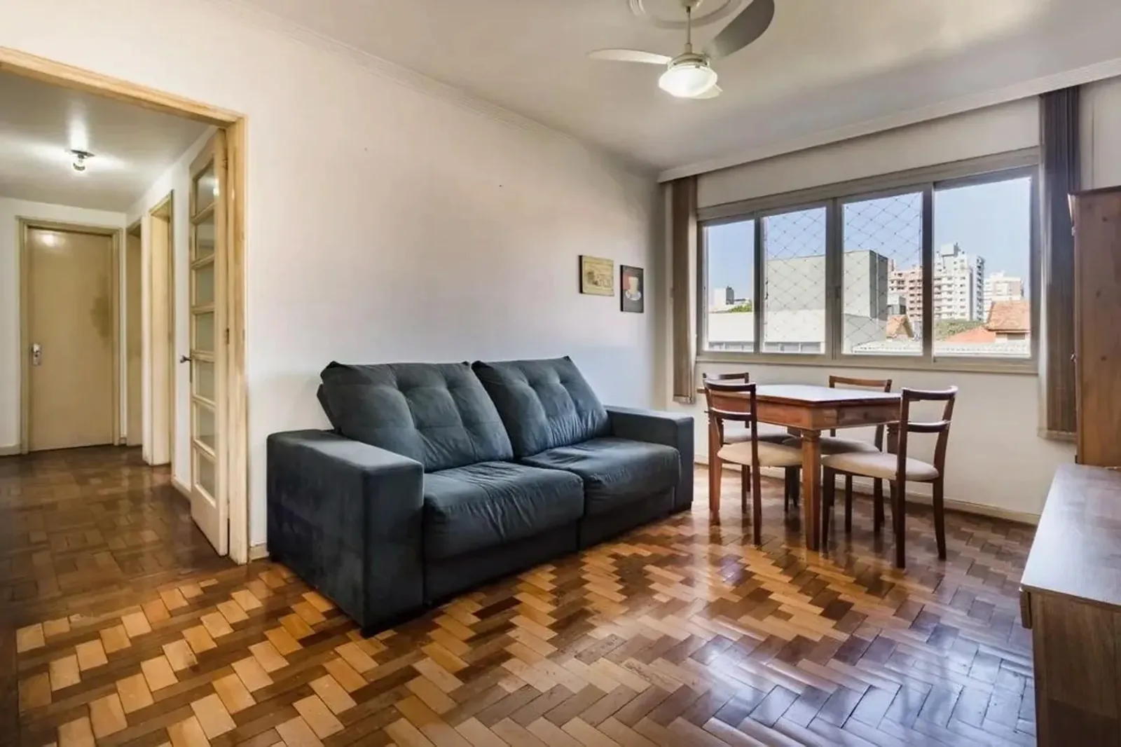 Sala com piso de parquê e janelas largas no Menino Deus, em Porto Alegre