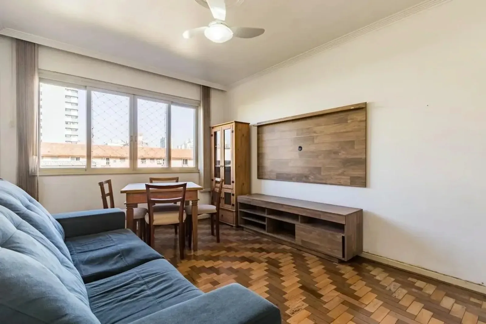 Sala vista da entrada, com estante de madeira