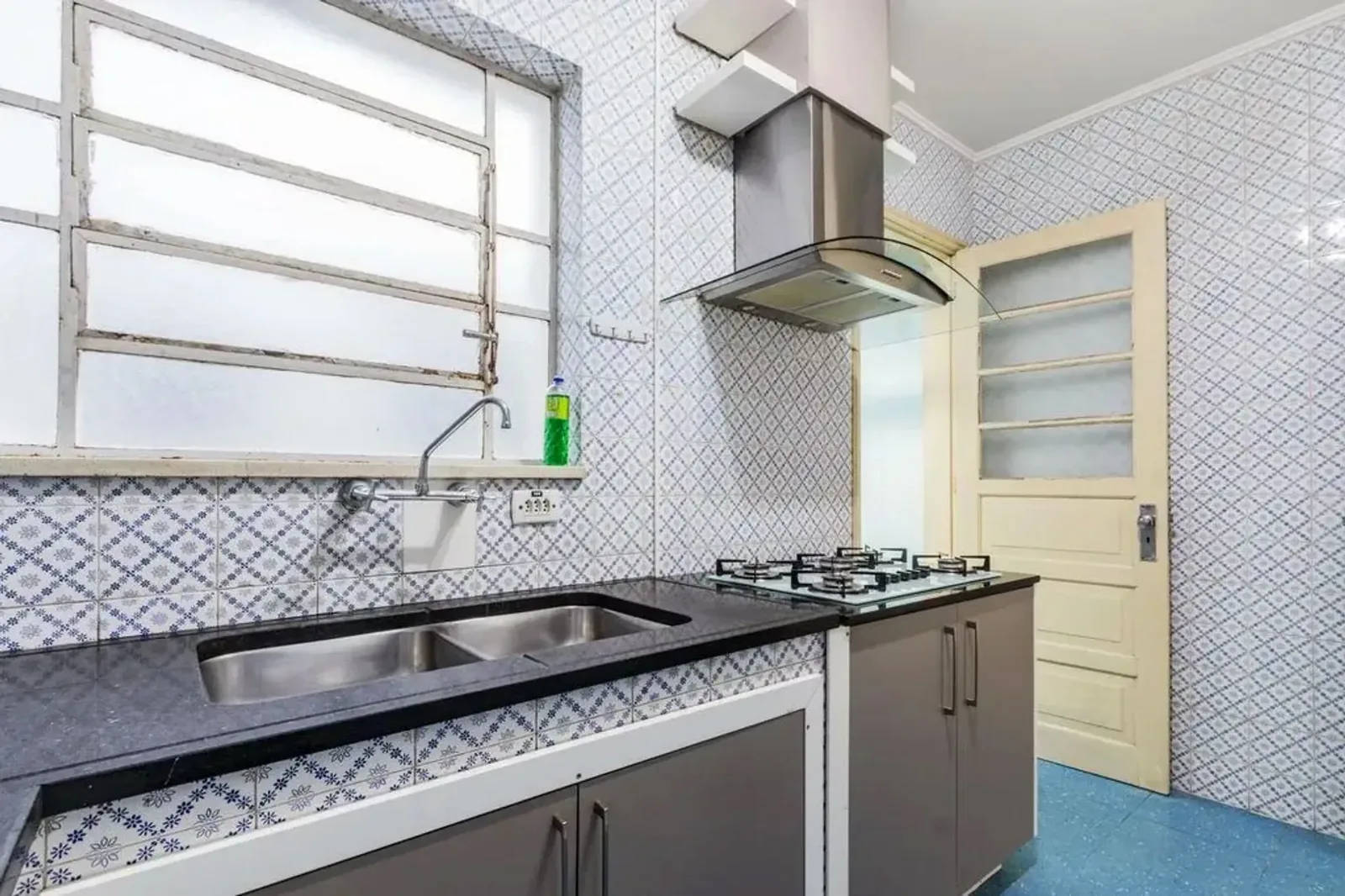 Cozinha com cooktop, coifa e bancada de granito