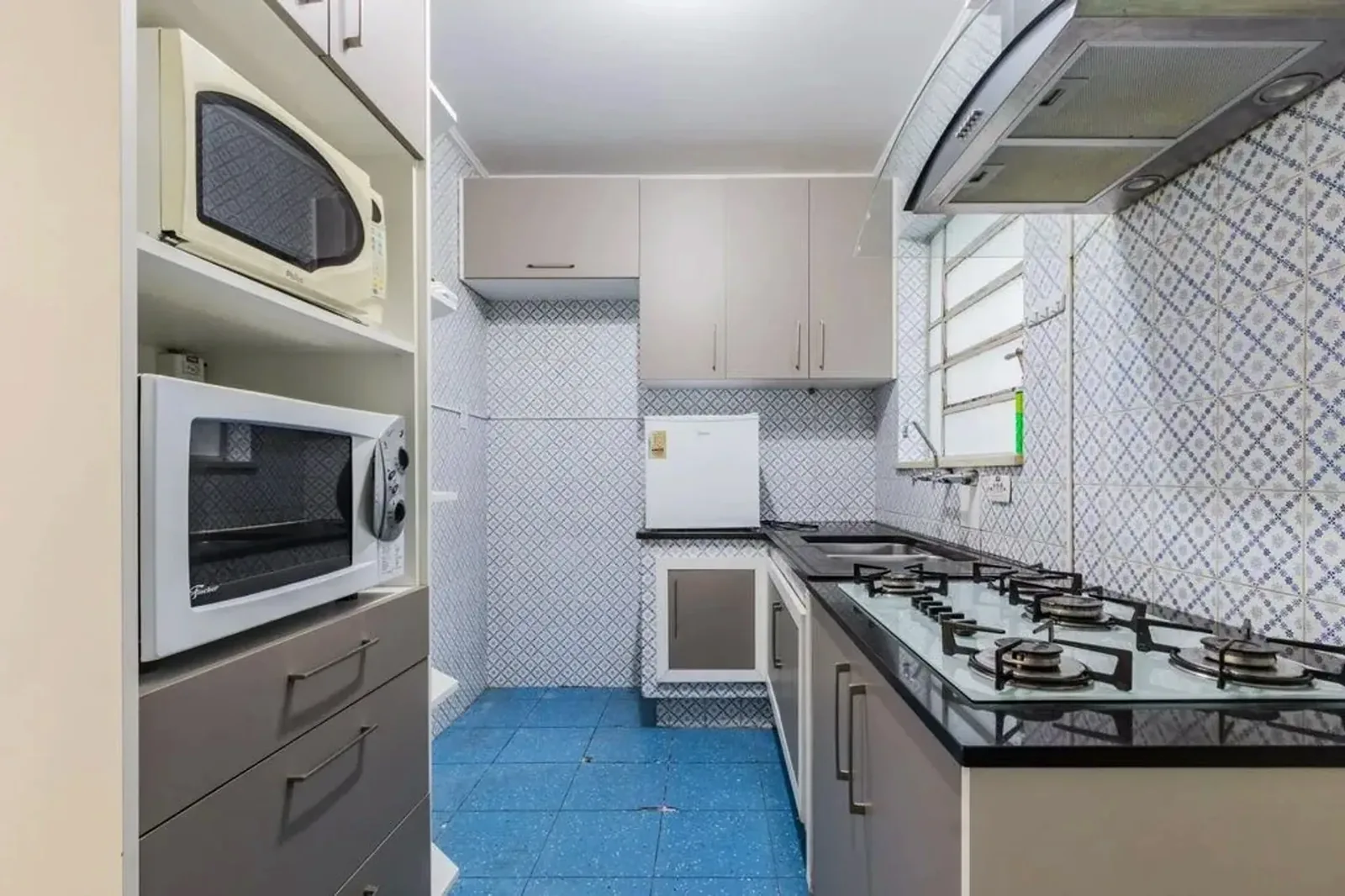 Cozinha com armários e micro-ondas embutido