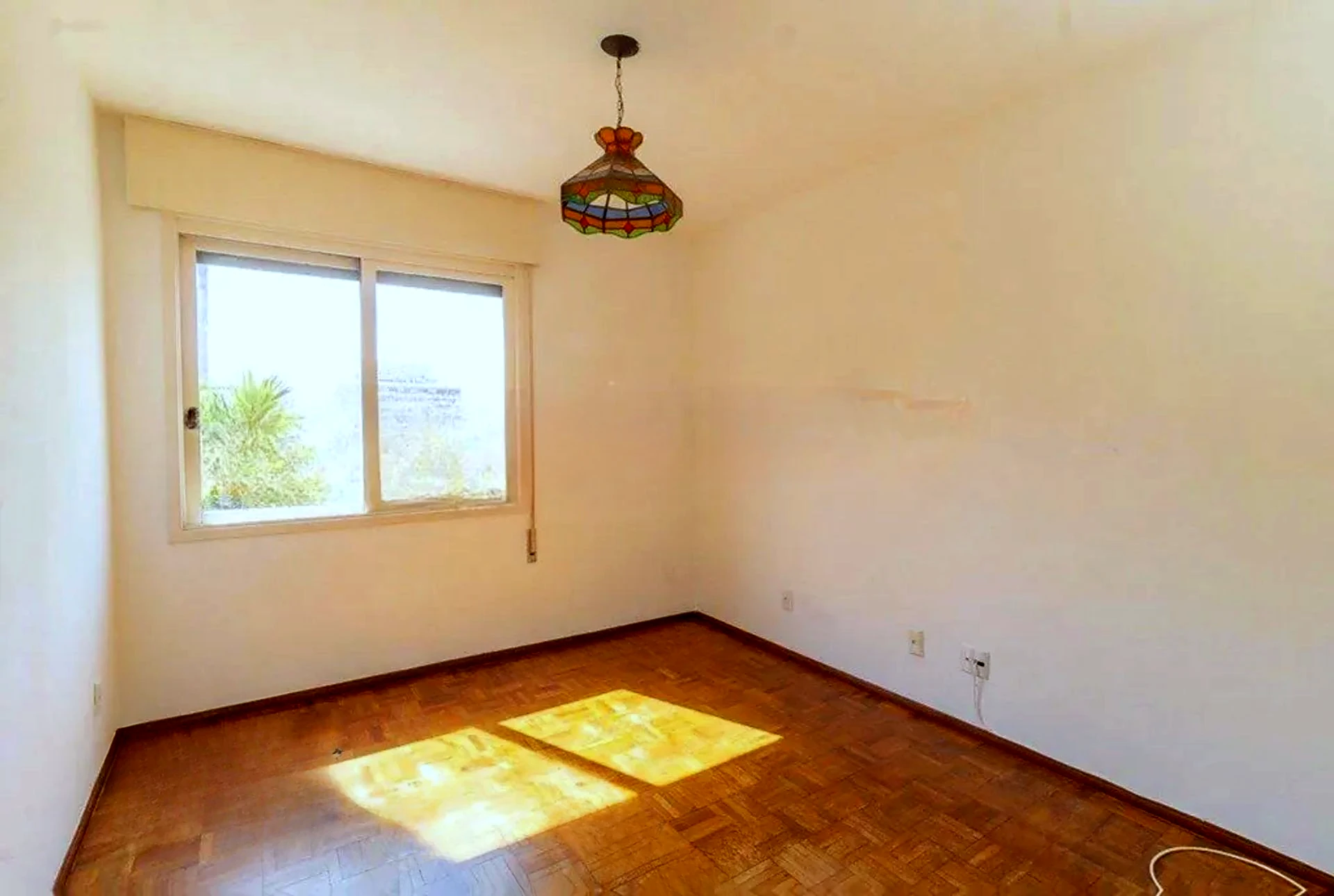 Living ensolarado com piso de parquet