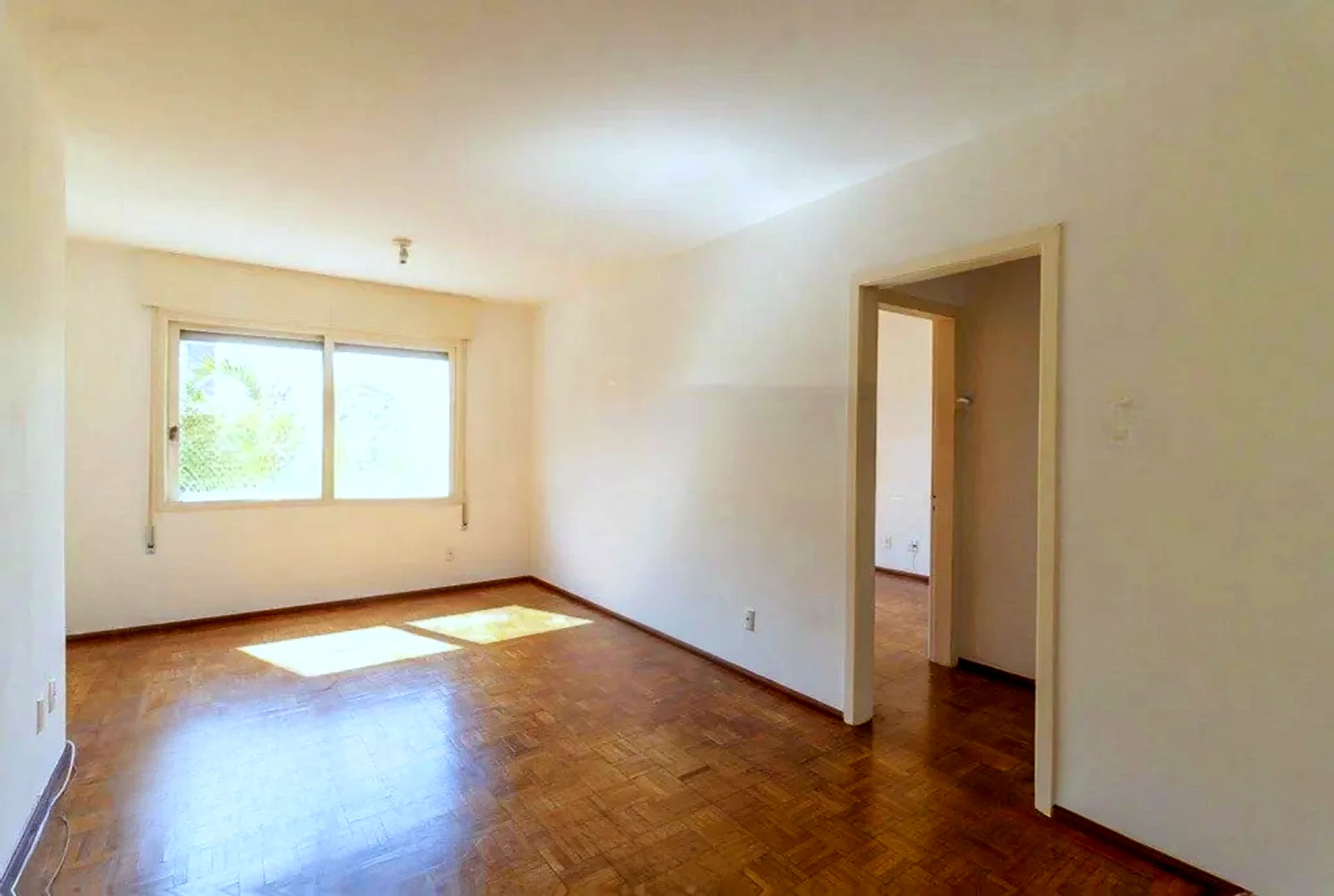 Living amplo com janela para a avenida