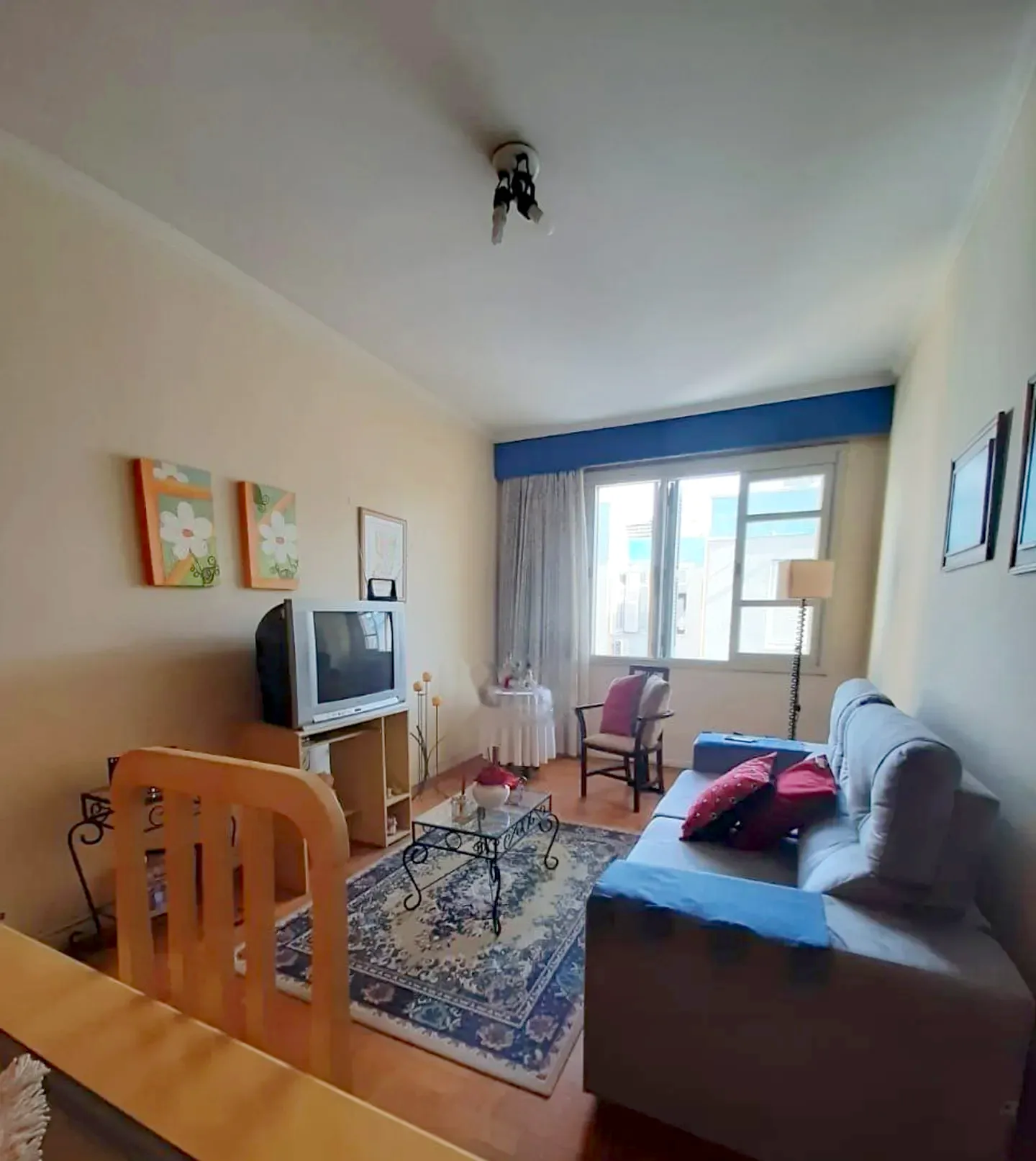 Living com piso de parquê e janela ampla