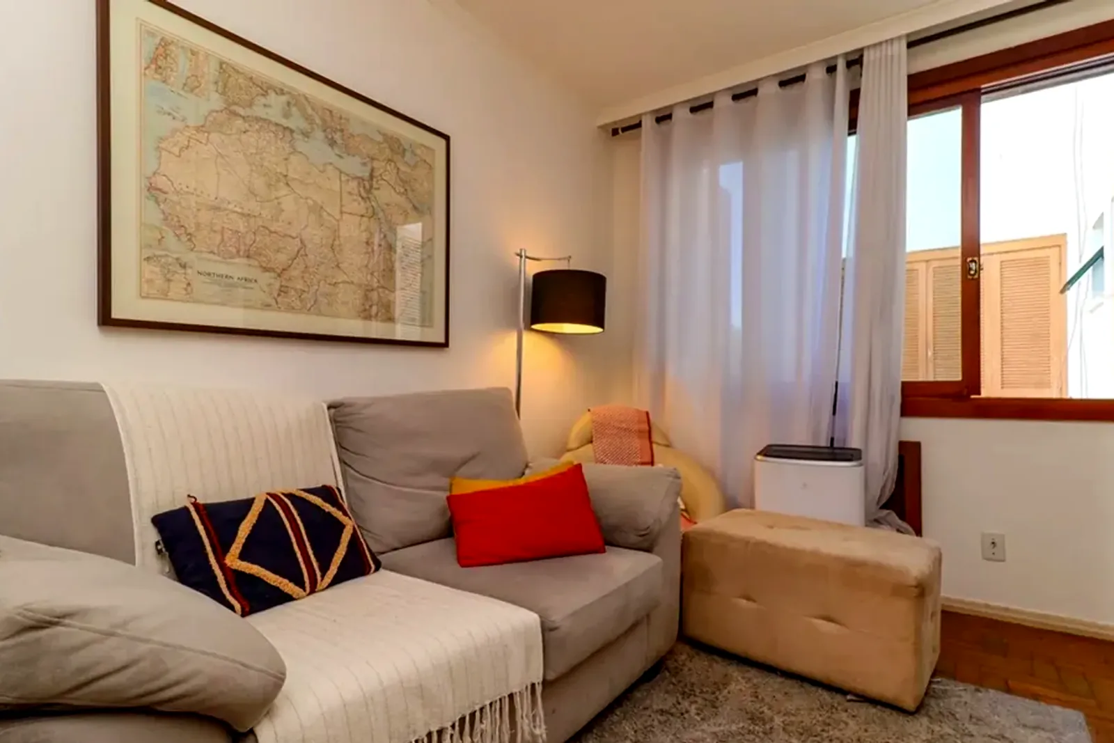 Sala com sofá e janela com cortinas
