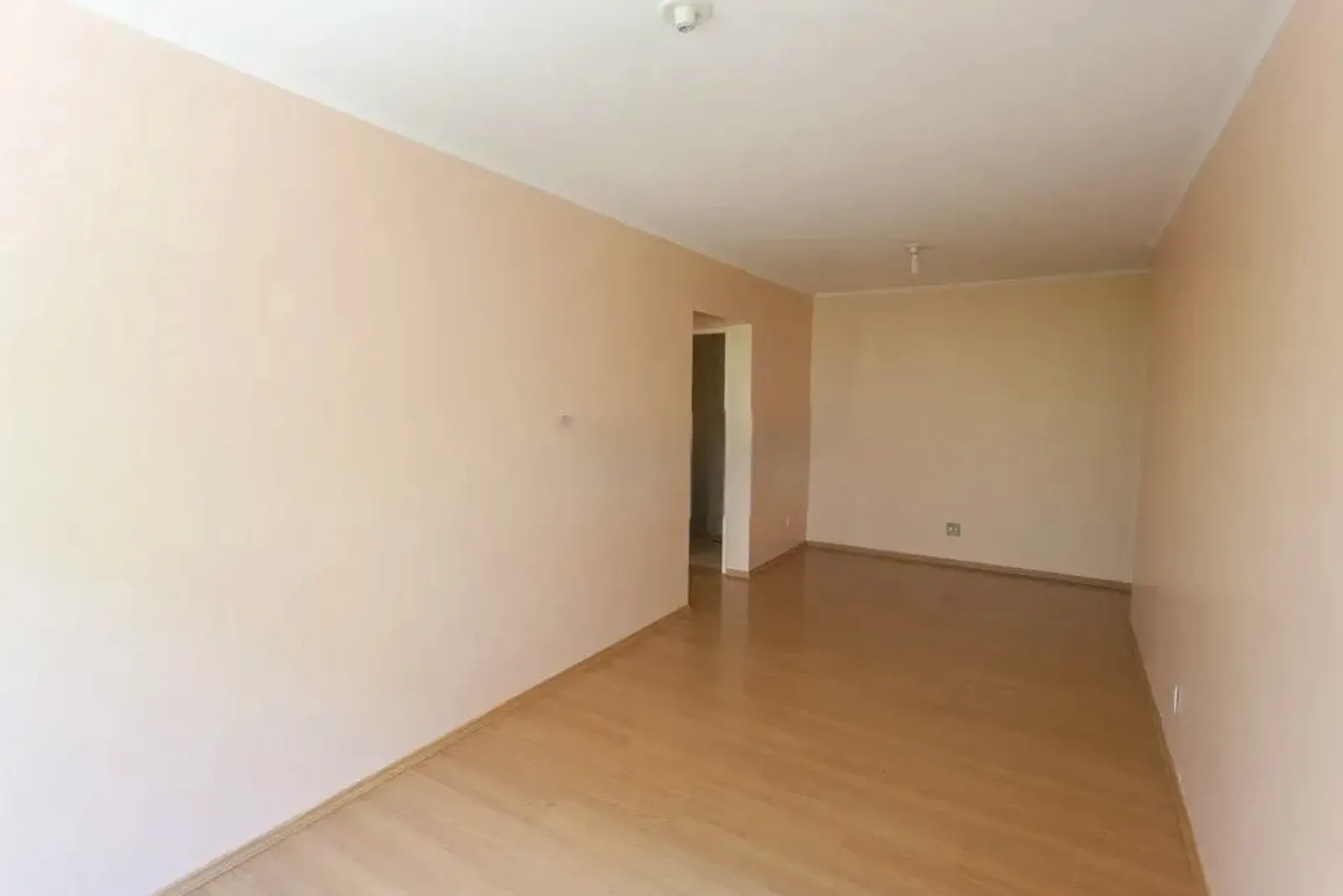 Peça ampla e clara com piso laminado