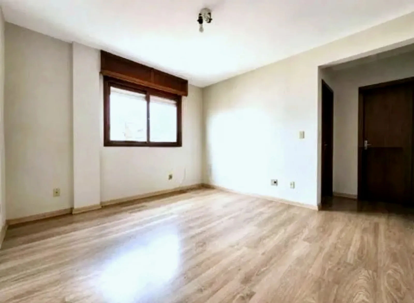 Living com piso laminado e janela de frente