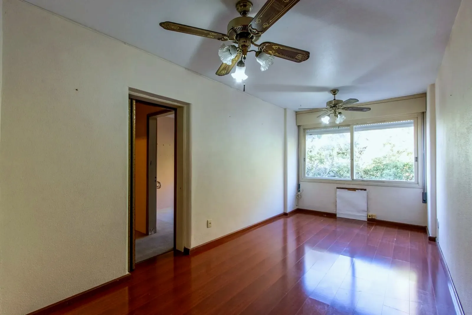 Living com piso laminado e janela ampla