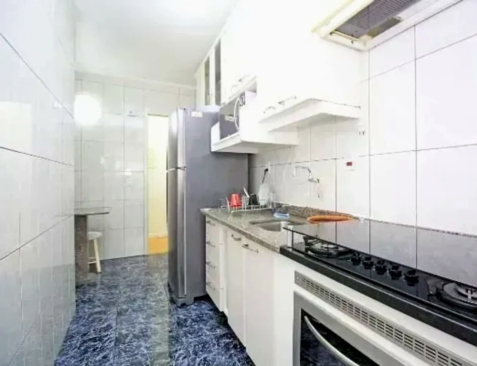 Cozinha com armários brancos e fogão embutido