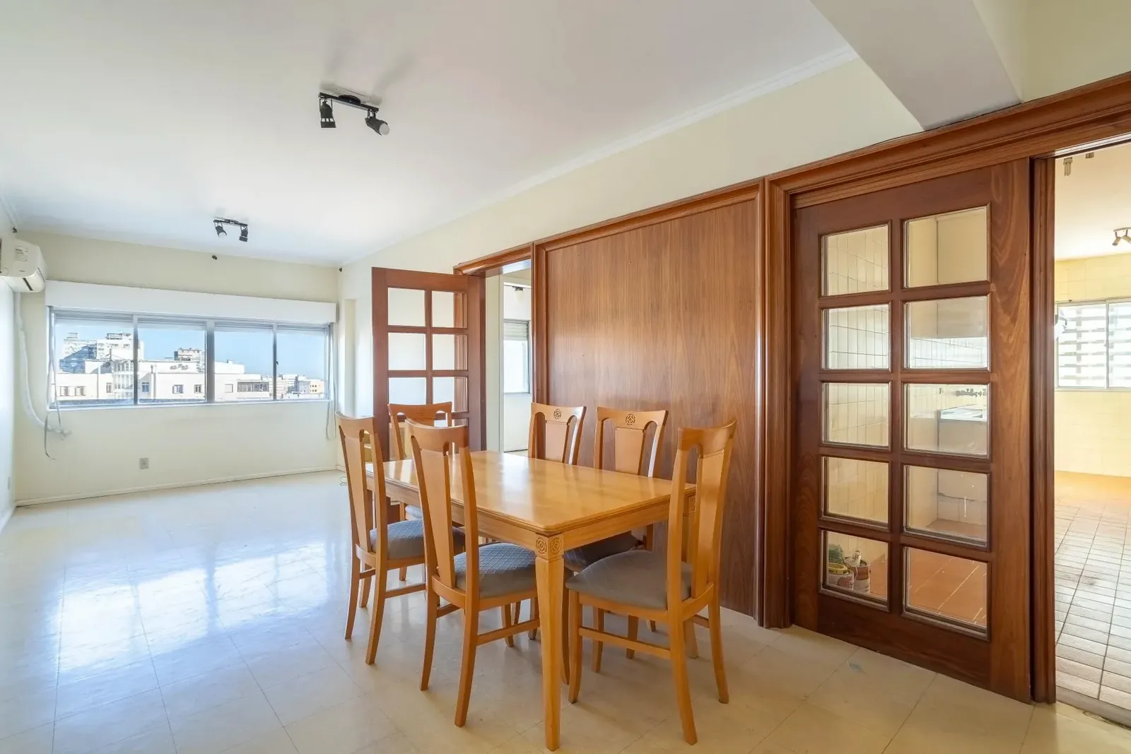 Living com mesa de jantar e janela para a cidade
