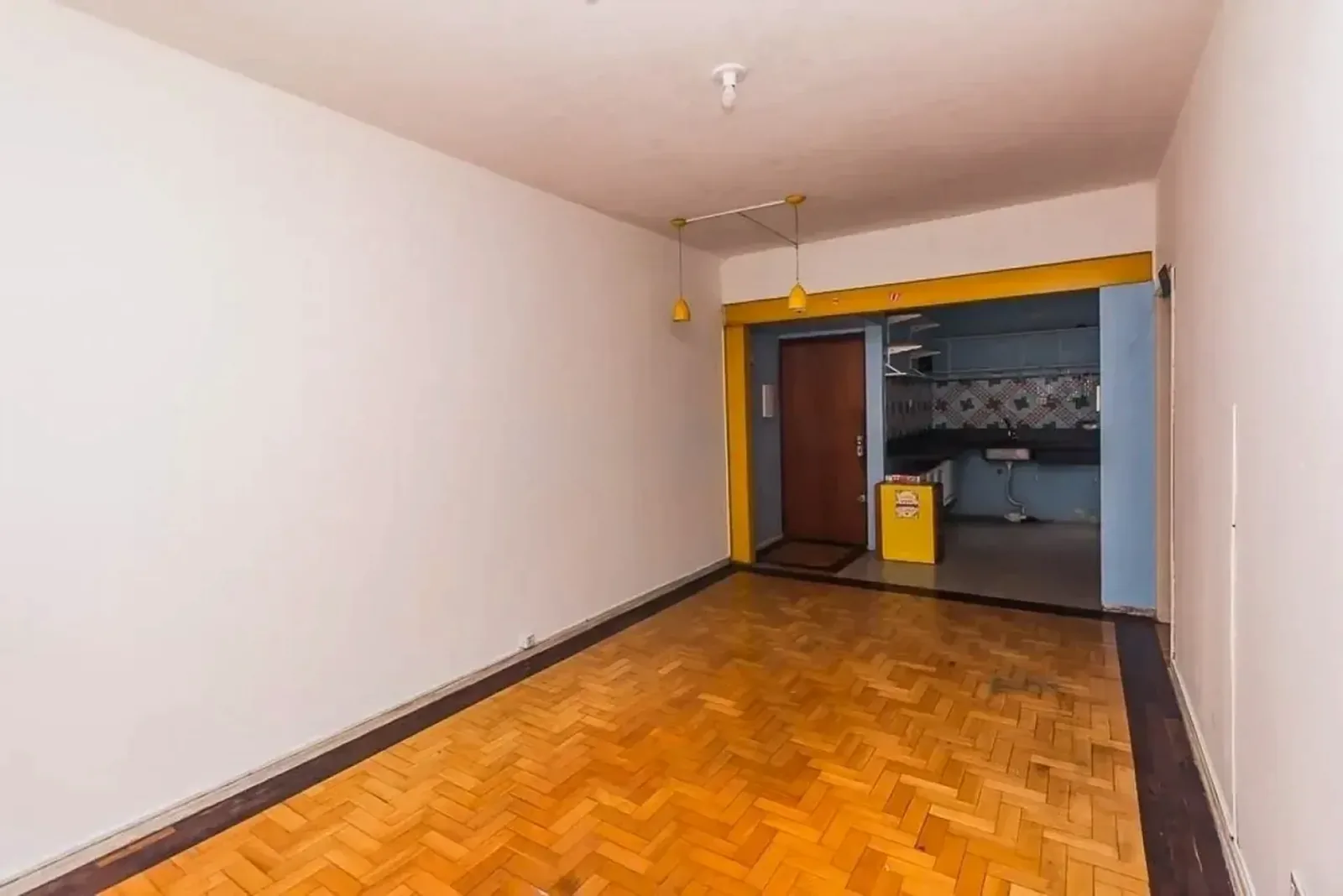 Living amplo com parquet e porta para a cozinha