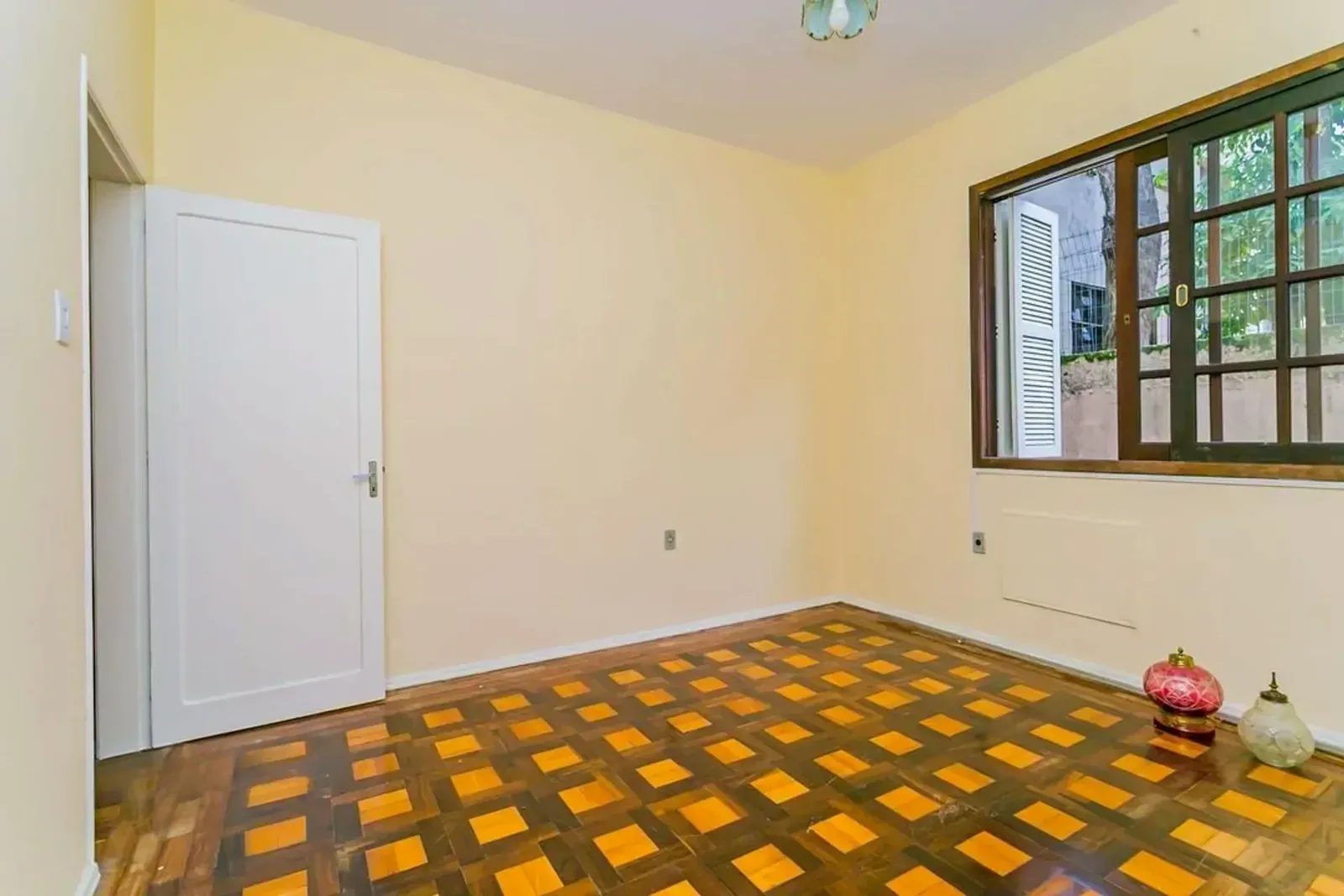 Dormitório com janela de madeira e parquet