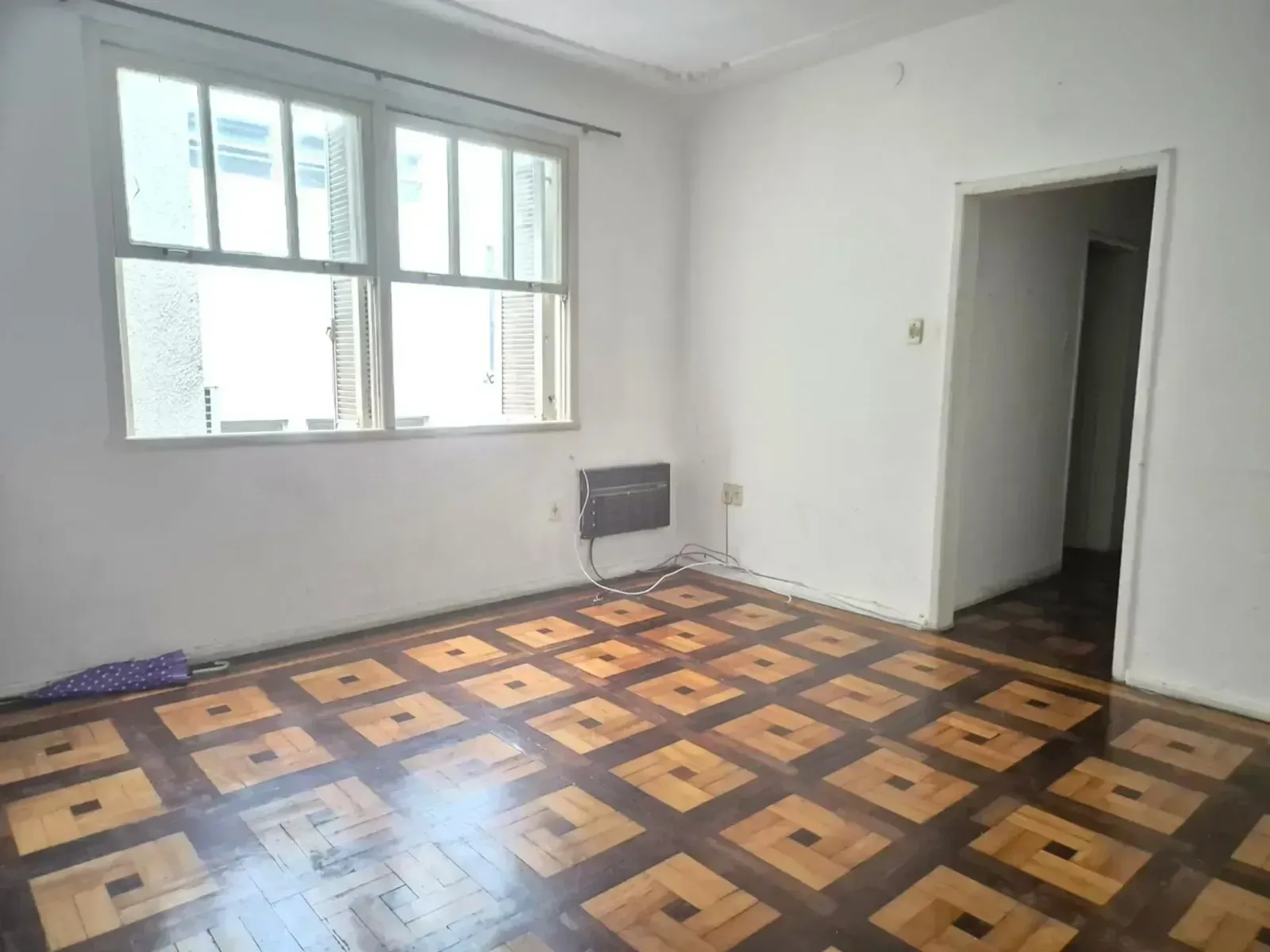 Dormitório com piso de parquet e janela ampla