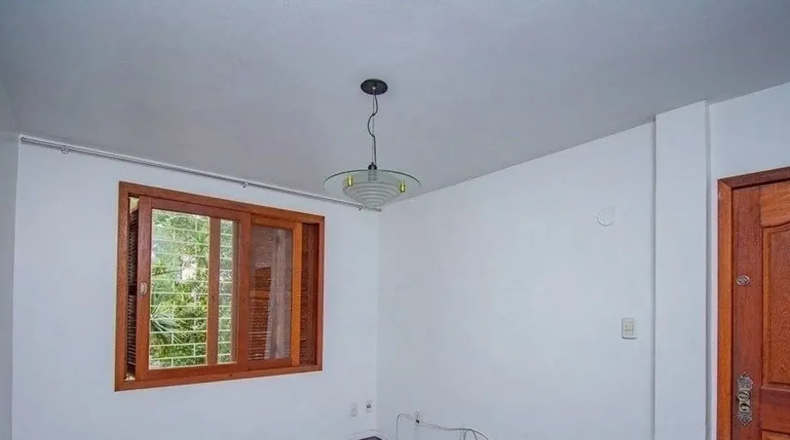 Sala com piso de parquê e janela de madeira em Petrópolis, Porto Alegre