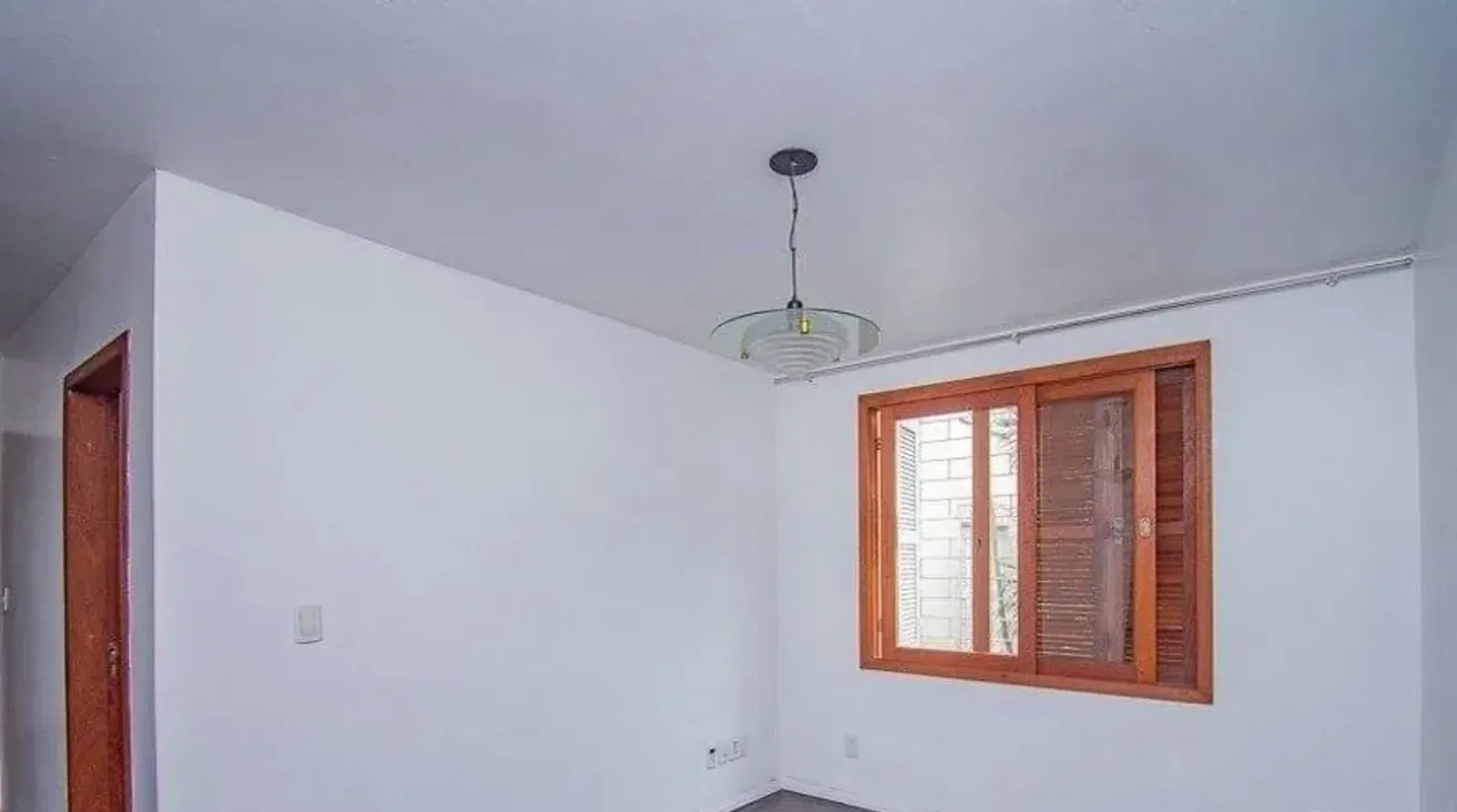 Sala vista do outro lado, com janela para as árvores