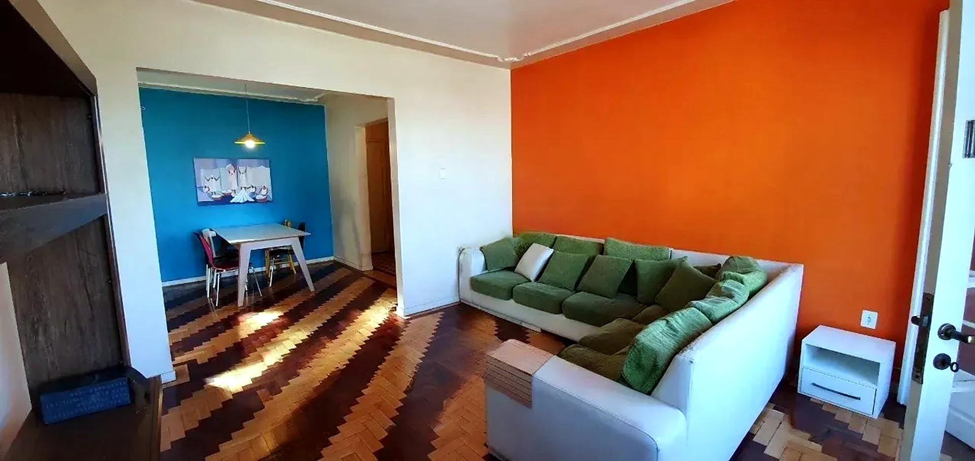 Living amplo com parquet e sofá