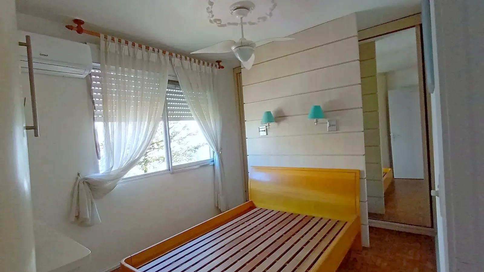 Dormitório com cama e cortinas