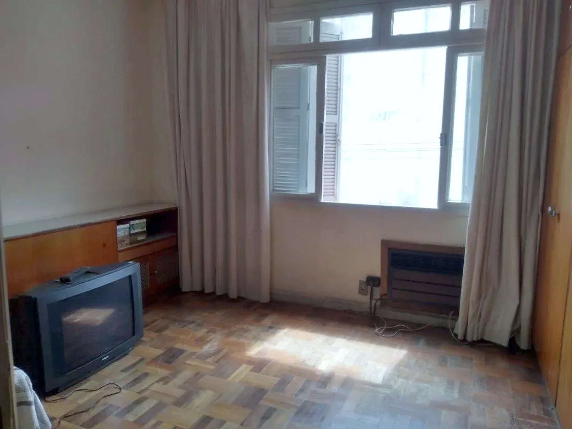 Dormitório com janela ampla e parquet