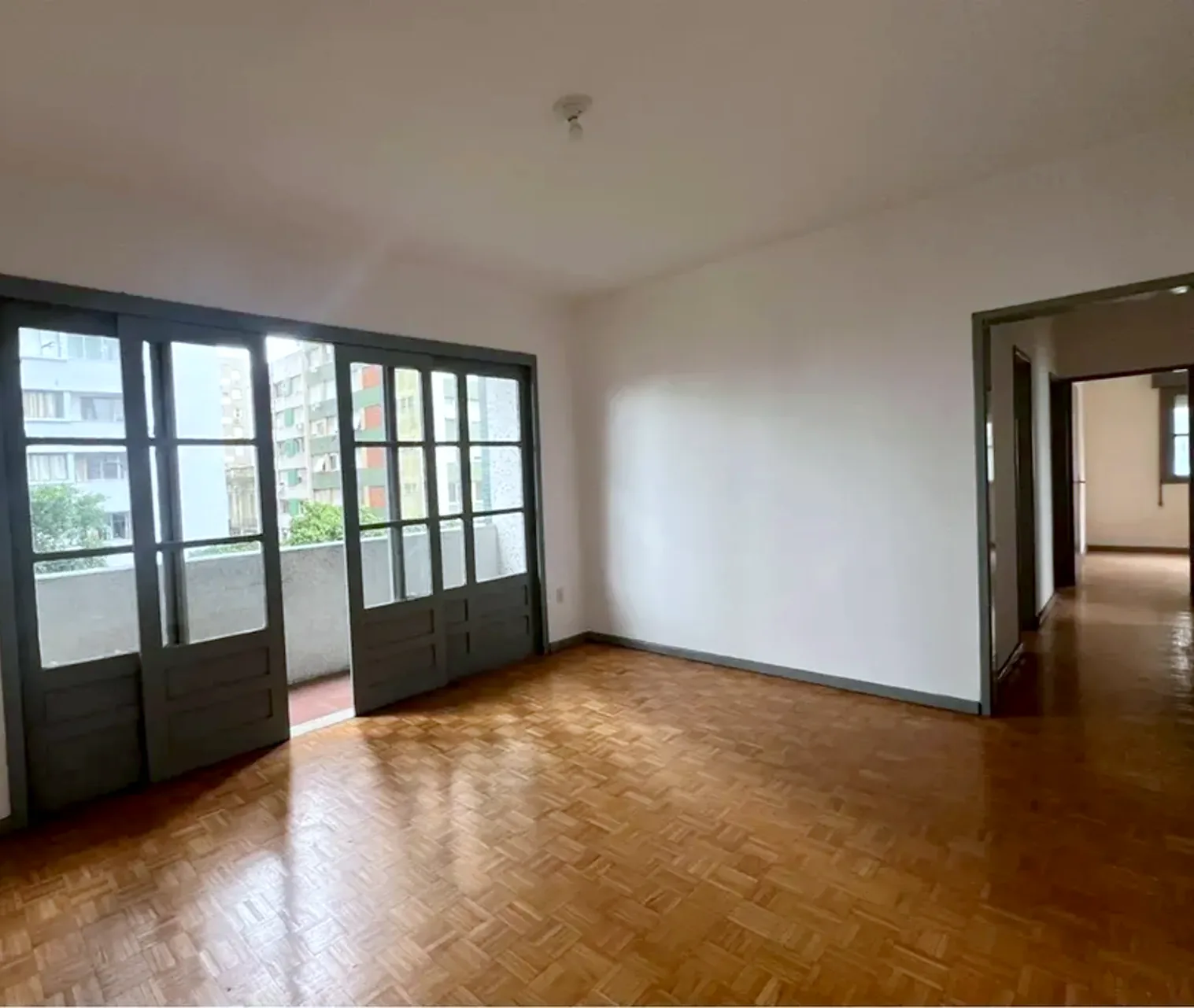 Sala com luz natural e piso de parquê