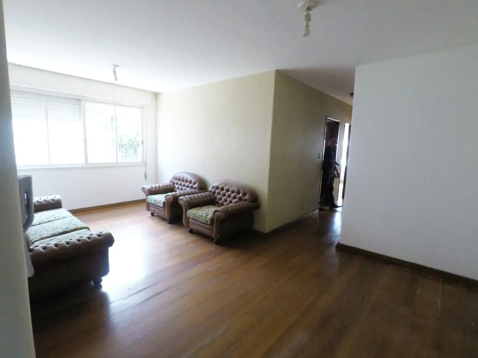 Living com piso de madeira e janela ampla