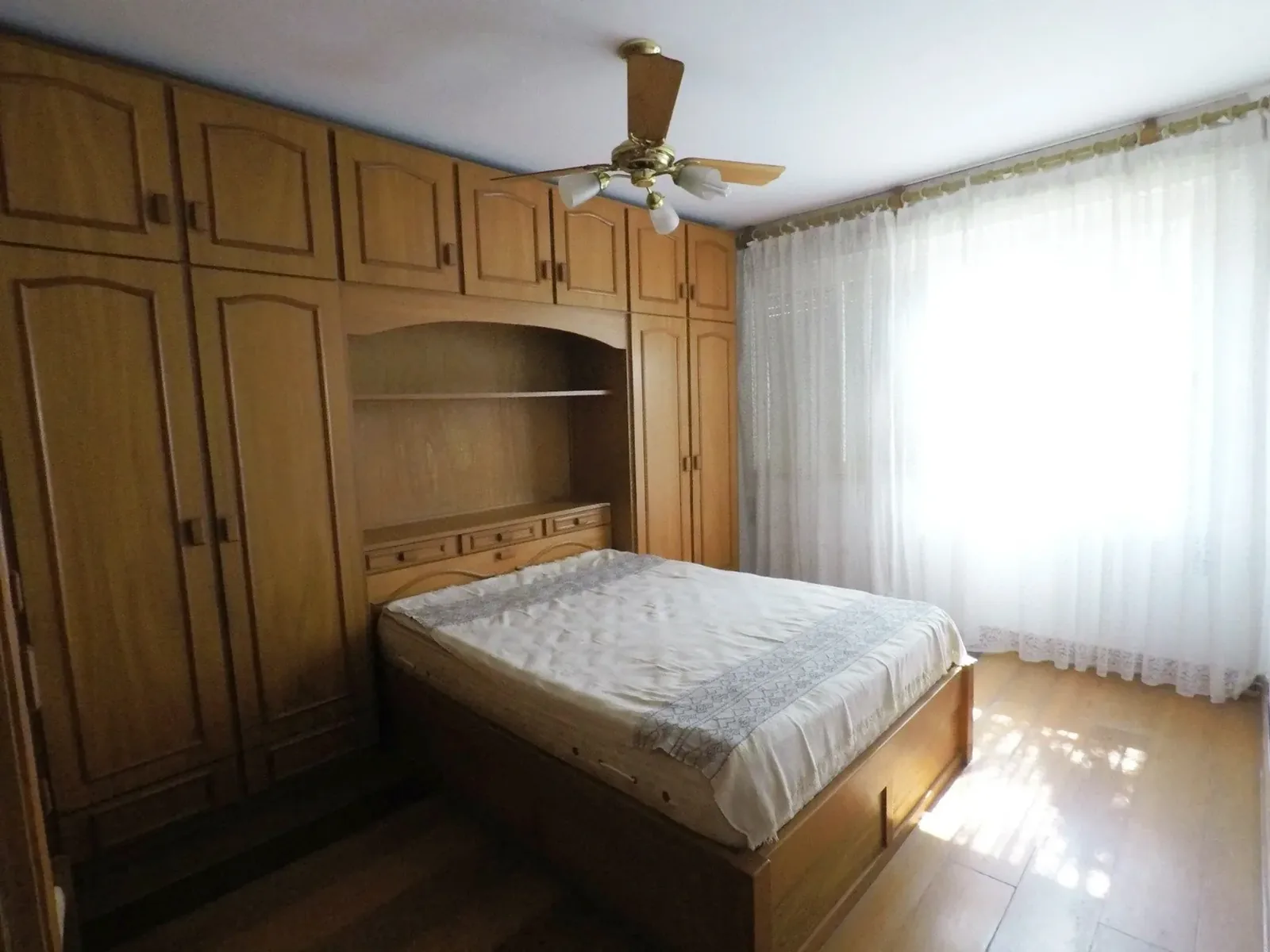 Dormitório com armário embutido e ventilador de teto
