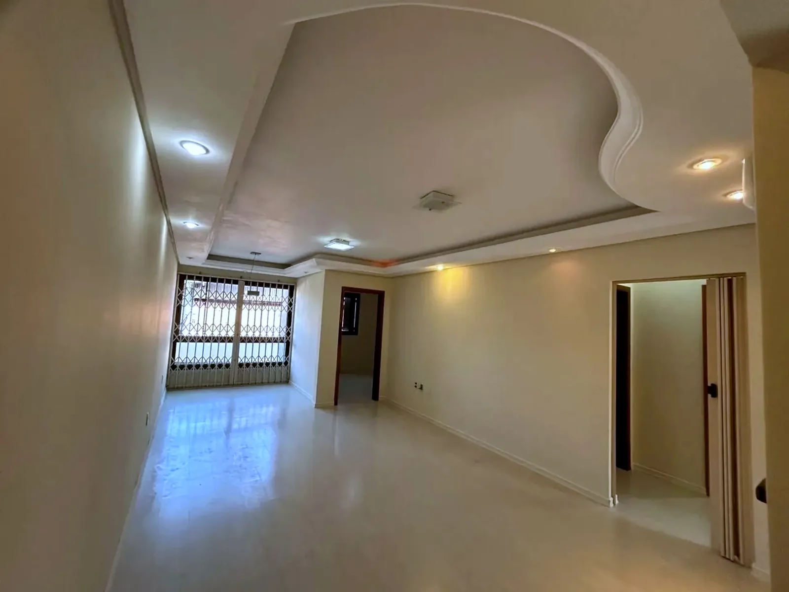 Living amplo com rebaixo de gesso e iluminação embutida